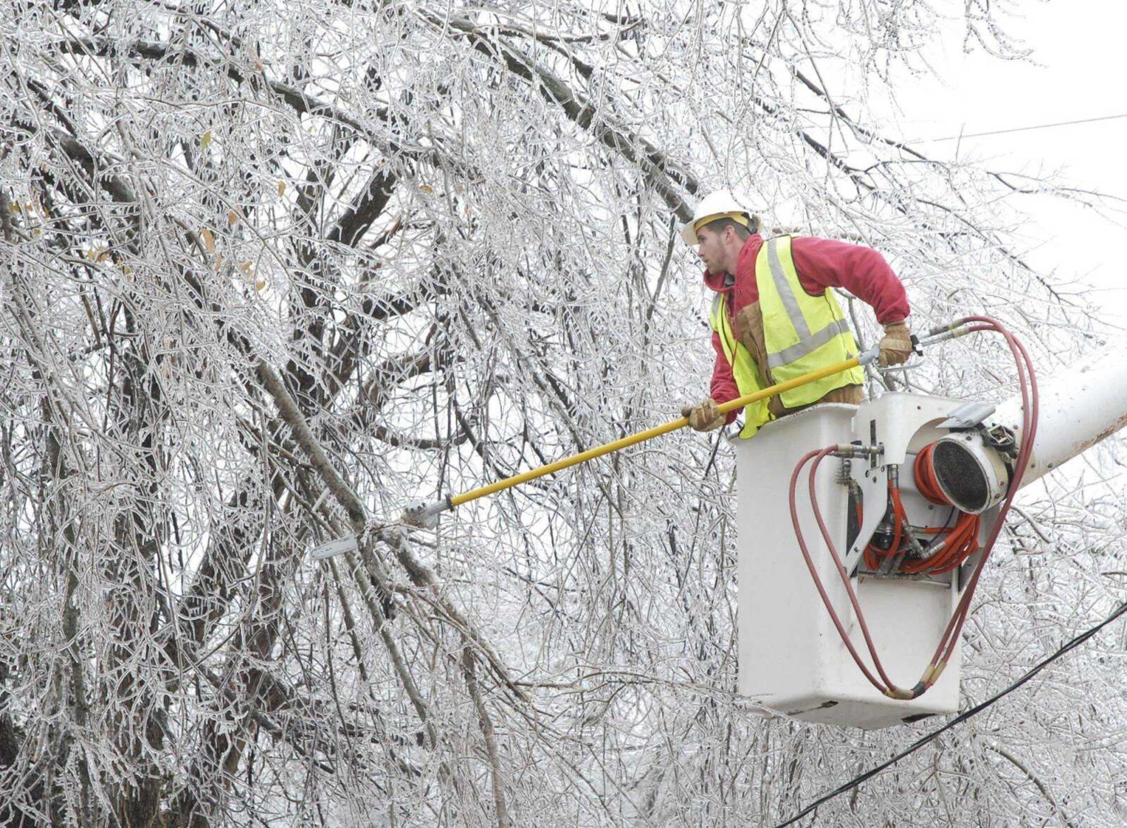 Tree trimmers from Shade Tree Service Company try to make way for the utility company to get power hooked up on Monday, Dec. 10, 2007,  in Jefferson City, MO.  Much of mid-Missouri continues to try and get mobile after a weekend ice storm. Area residents are busy picking up broken branches and in some instances, entire trees were that were uprooted. The majority of the damage was caused by large broken branches falling onto houses and automobiles in addition to power lines. (AP Photo/News Tribune,Julie Smith)