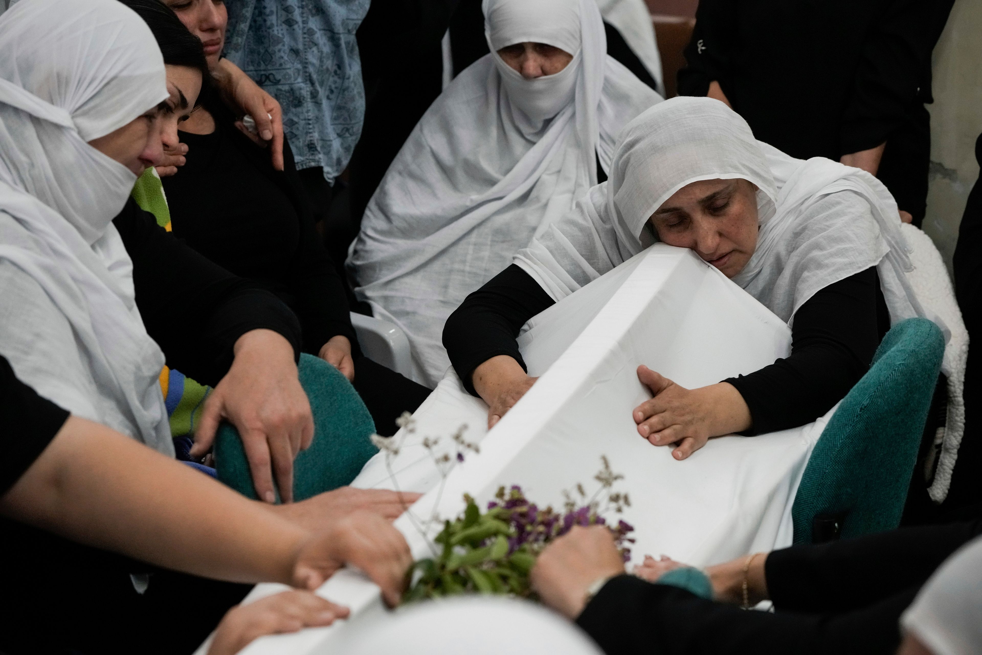 Members of the Druze minority mourn during the funeral of their relatives at the village of Majdal Shams in the Israeli-controlled Golan Heights, Sunday, July 28, 2024. A rocket strike at a soccer field in the village has killed at least 11 children and teens. It's the deadliest strike on an Israeli target along the country's northern border since the fighting between Israel and the Lebanese militant group Hezbollah began. (AP Photo/Leo Correa)