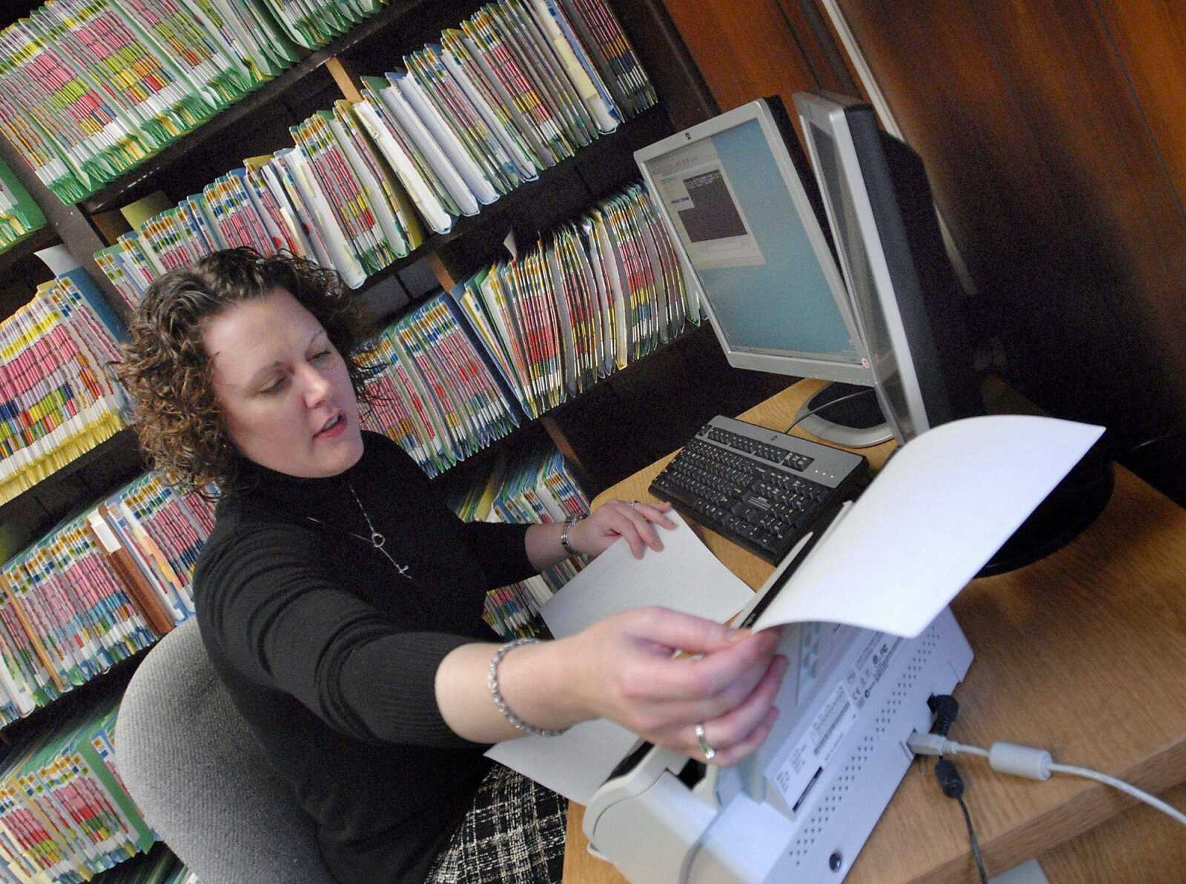 Deputy circuit clerk Courtney Bemo scans court documents Thursday at the Common Pleas Courthouse in Cape Girardeau. Rooms full of these files are being scanned and converted into electronic records that can be accessed on Missouri Case.net. (Kristin Eberts)