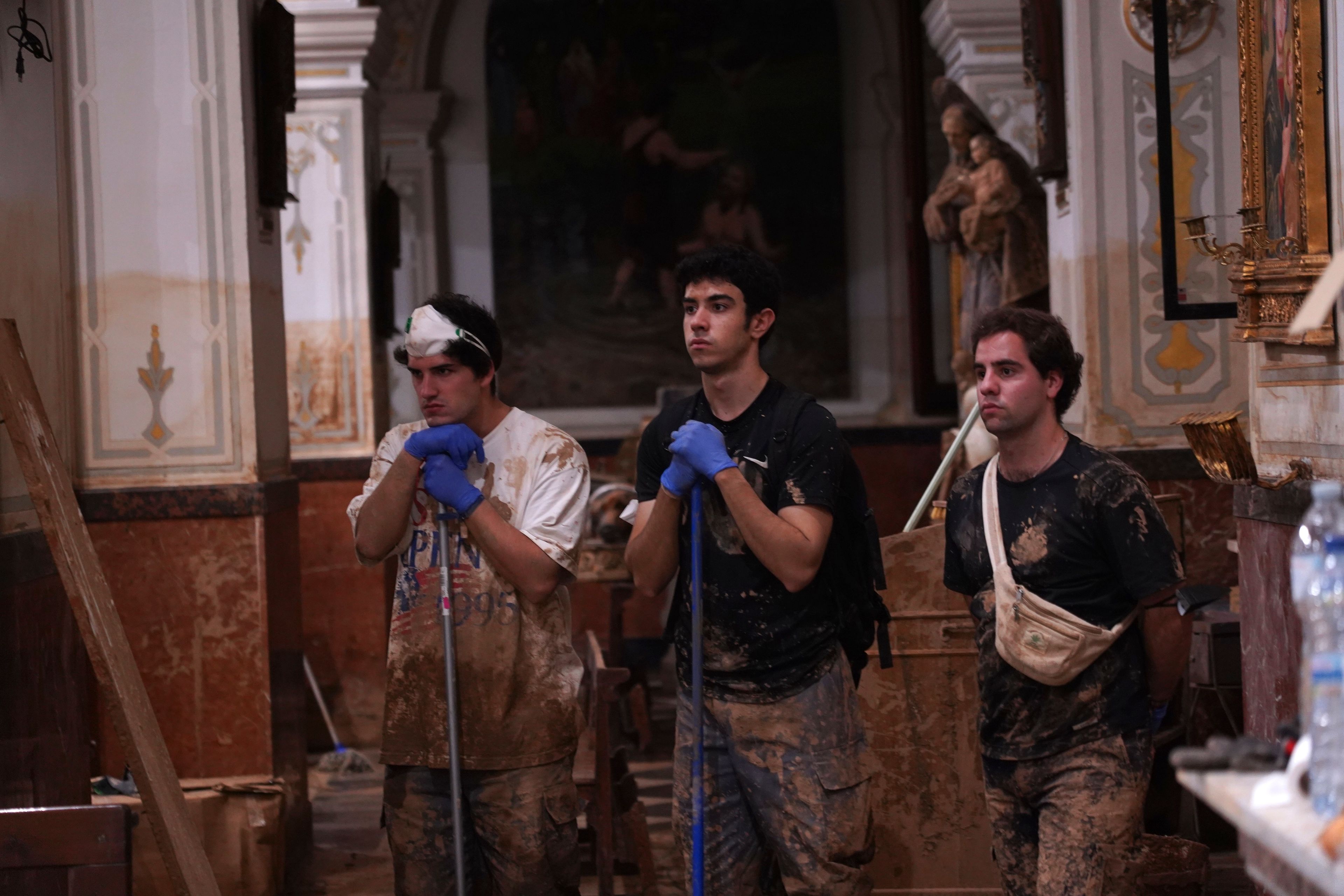 People who have been working in the clean-up attend a mass at the San Jorge church after floods in Paiporta, Spain, Thursday, Nov. 7, 2024. (AP Photo/Alberto Saiz)