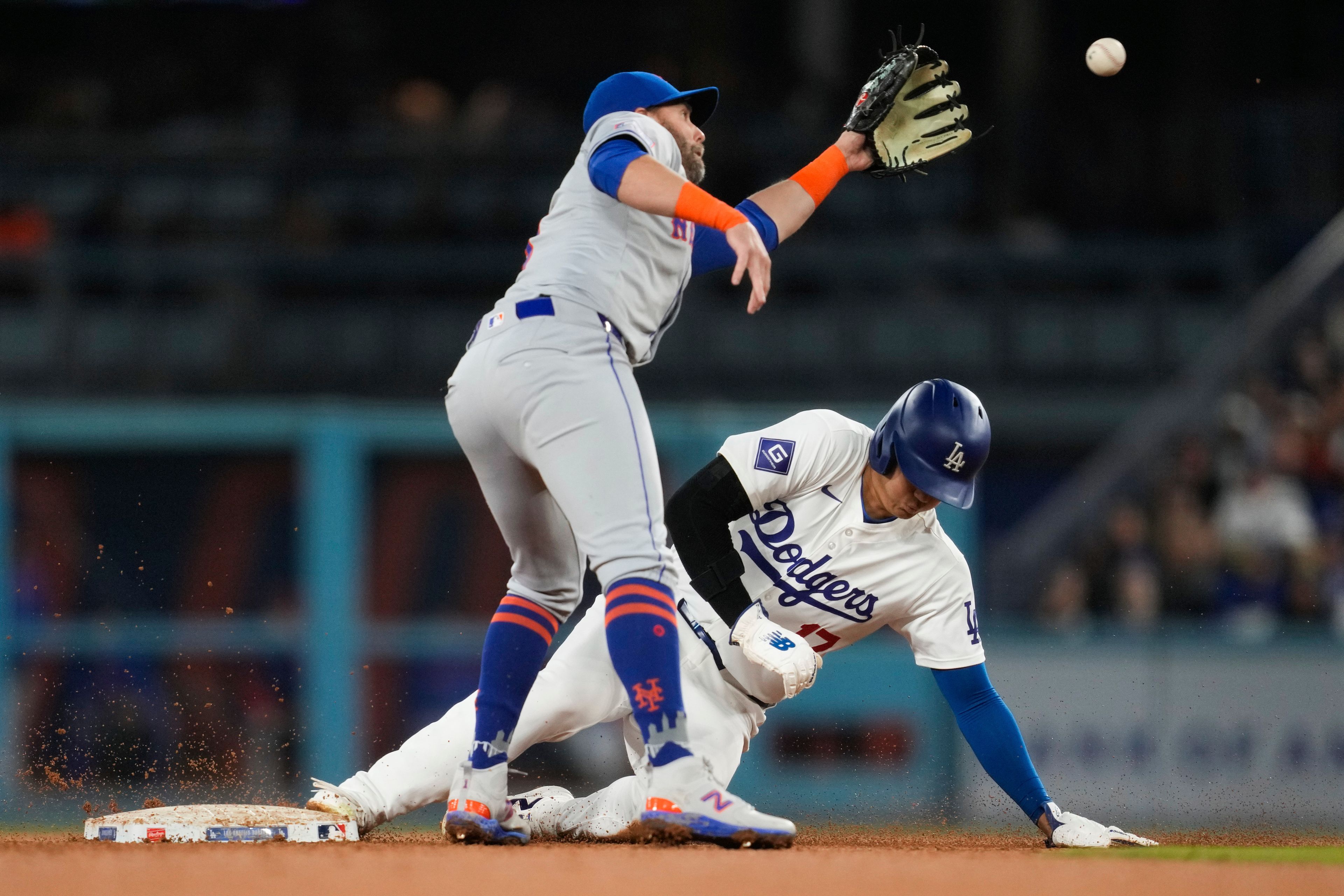 Los Angeles Dodgers designated hitter Shohei Ohtani (17) steals second ahead of a throw to New York Mets second baseman Jeff McNeil during the fourth inning of a baseball game in Los Angeles, Friday, April 19, 2024. (AP Photo/Ashley Landis)