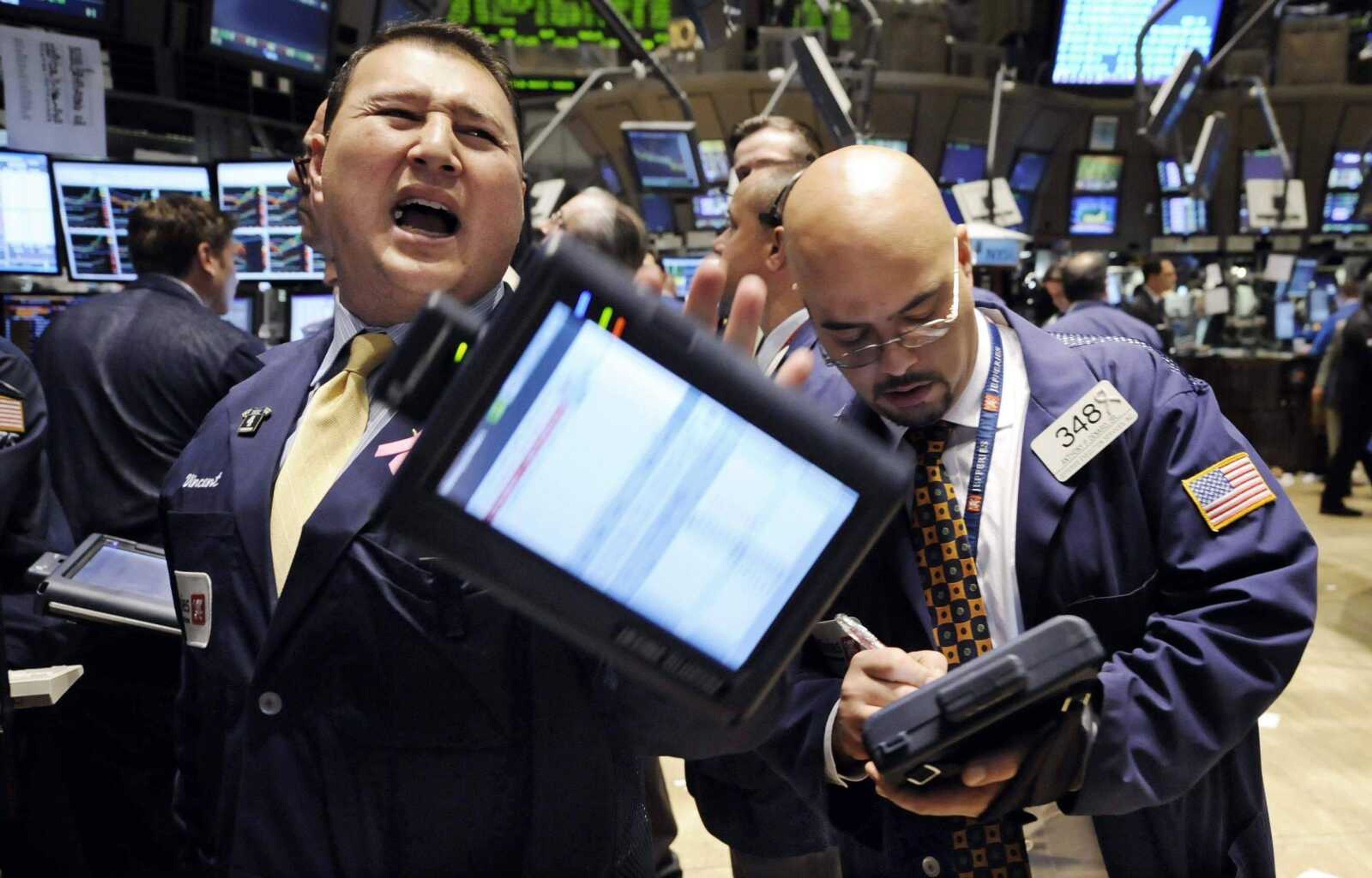 Traders work Thursday at the New York Stock Exchange. The Dow Jones industrial average rose nearly 553 points as investors decided they did not want to miss out on cheap stocks. <br>Richard Drew<br>Associated Press