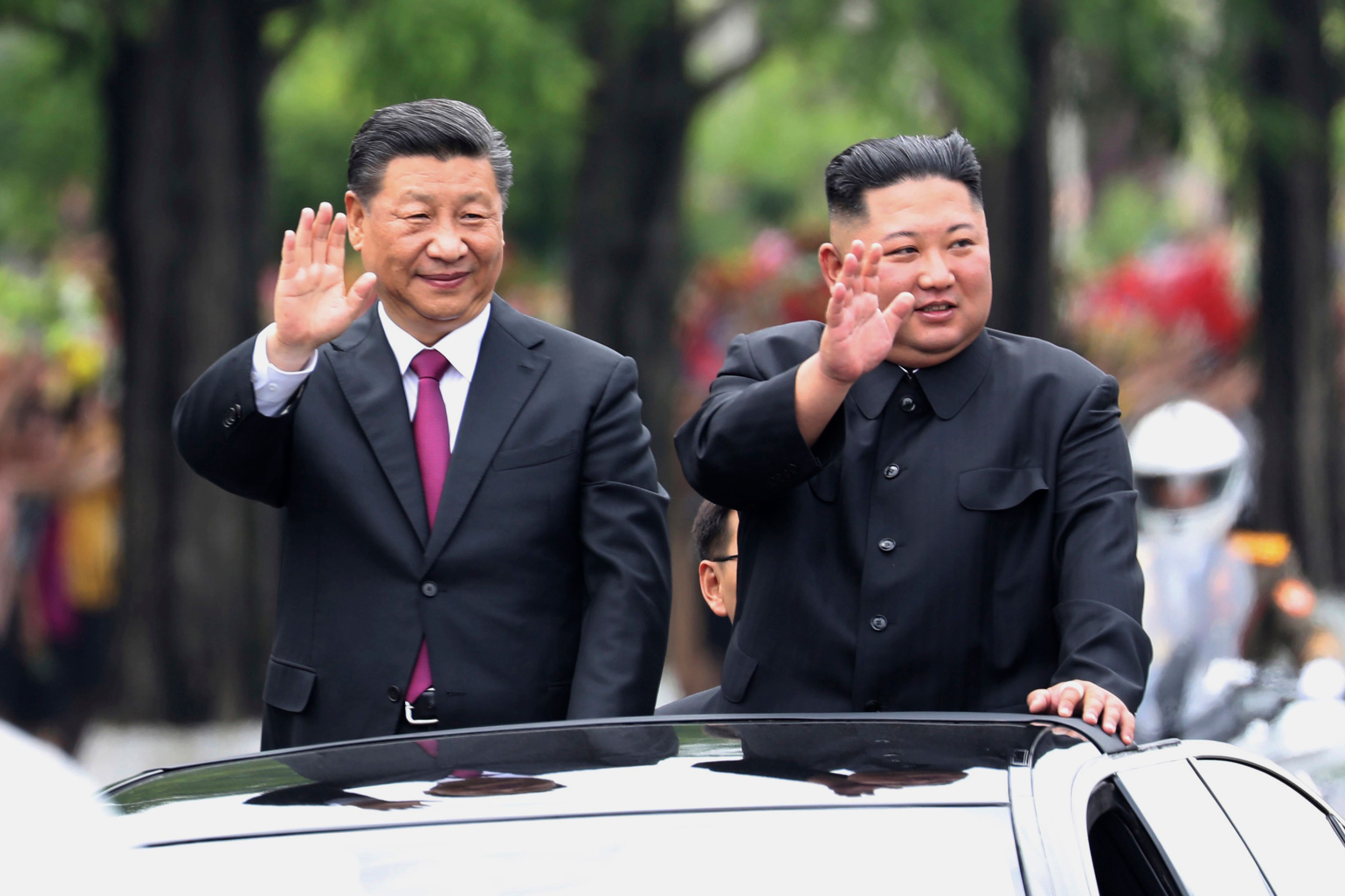 FILE - In this photo released by China's Xinhua News Agency, visiting Chinese President Xi Jinping, left, and North Korean leader Kim Jong Un wave from an open top limousine as they travel along a street in Pyongyang, North Korea, on June 20, 2019. (Ju Peng/Xinhua via AP, File)