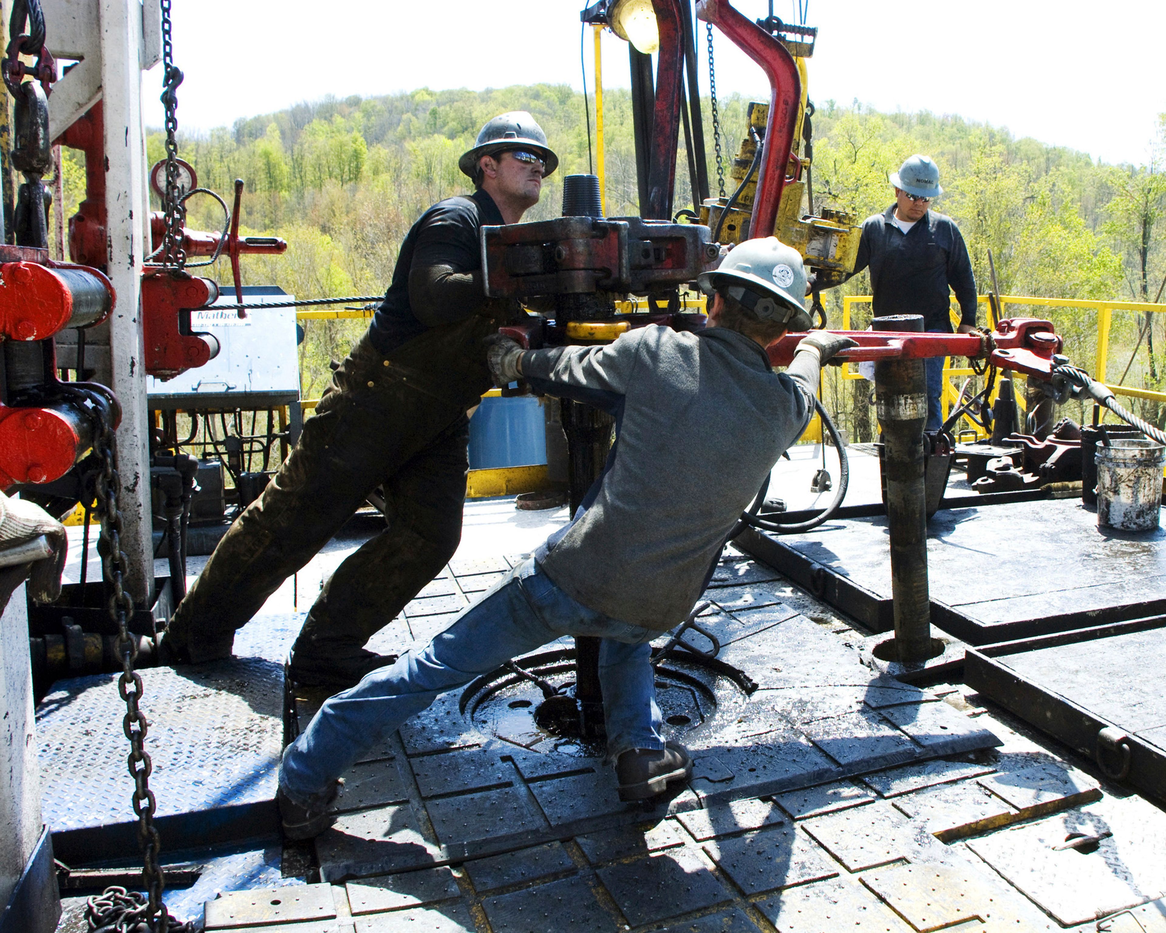 FILE - Workers move a section of well casing into place at a Chesapeake Energy natural gas well site near Burlington, Pa., in Bradford County, on April 23, 2010. (AP Photo/Ralph Wilson, File)