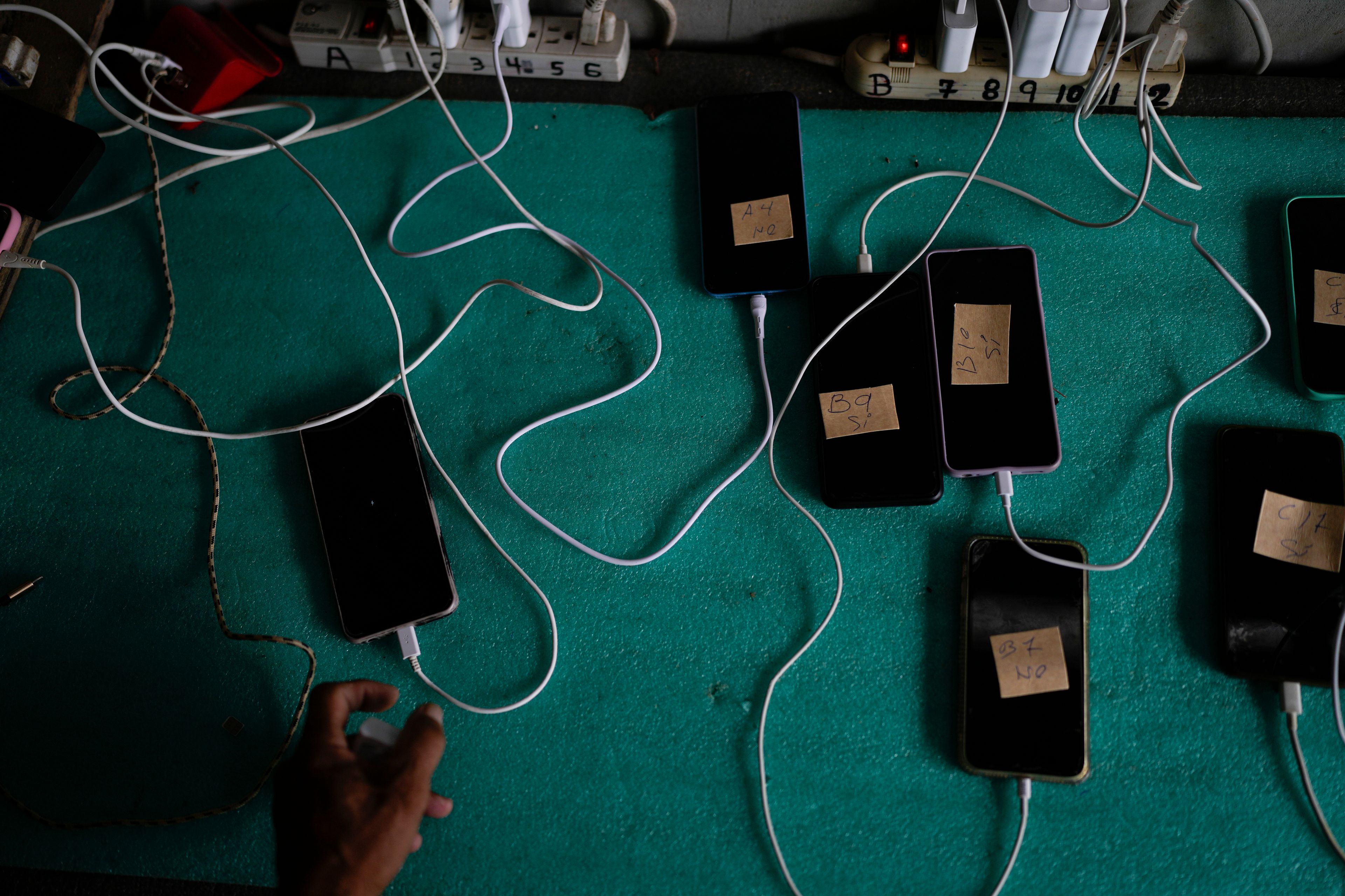 The cell phones of migrants get their batteries charged for a cost of $1 dollar per hour at a camp for people who walked across the Darien Gap in hopes of reaching the U.S., in Lajas Blancas, Panama, Thursday, Sept. 26, 2024. (AP Photo/Matias Delacroix)