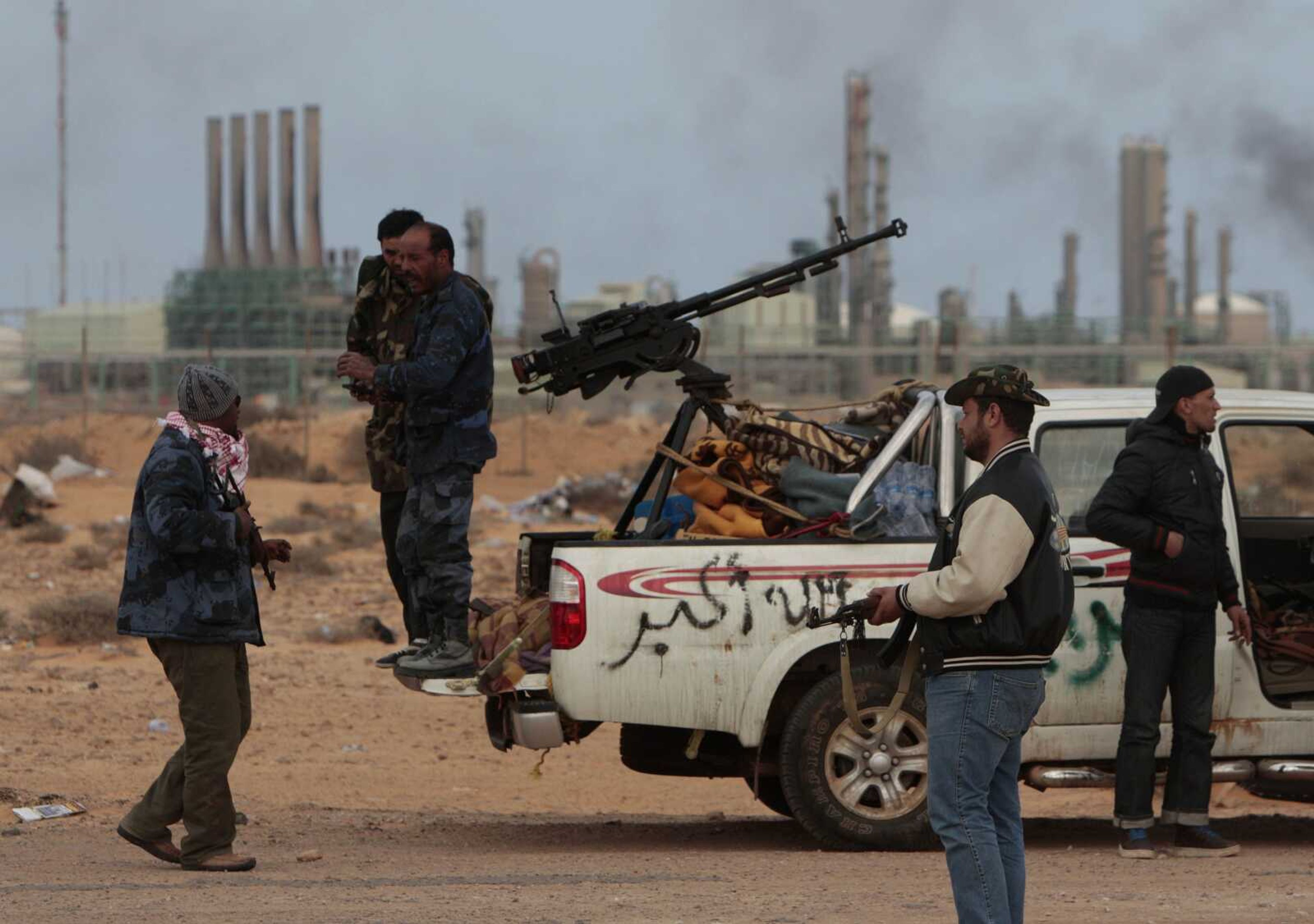 Anti-Gadhafi rebels prepare Thursday to leave their position in front of the oil refinery complex in Ras Lanouf, Libya. Government forces drove hundreds of rebels from the strategic oil port. (Hussein Malla ~ Associated Press)