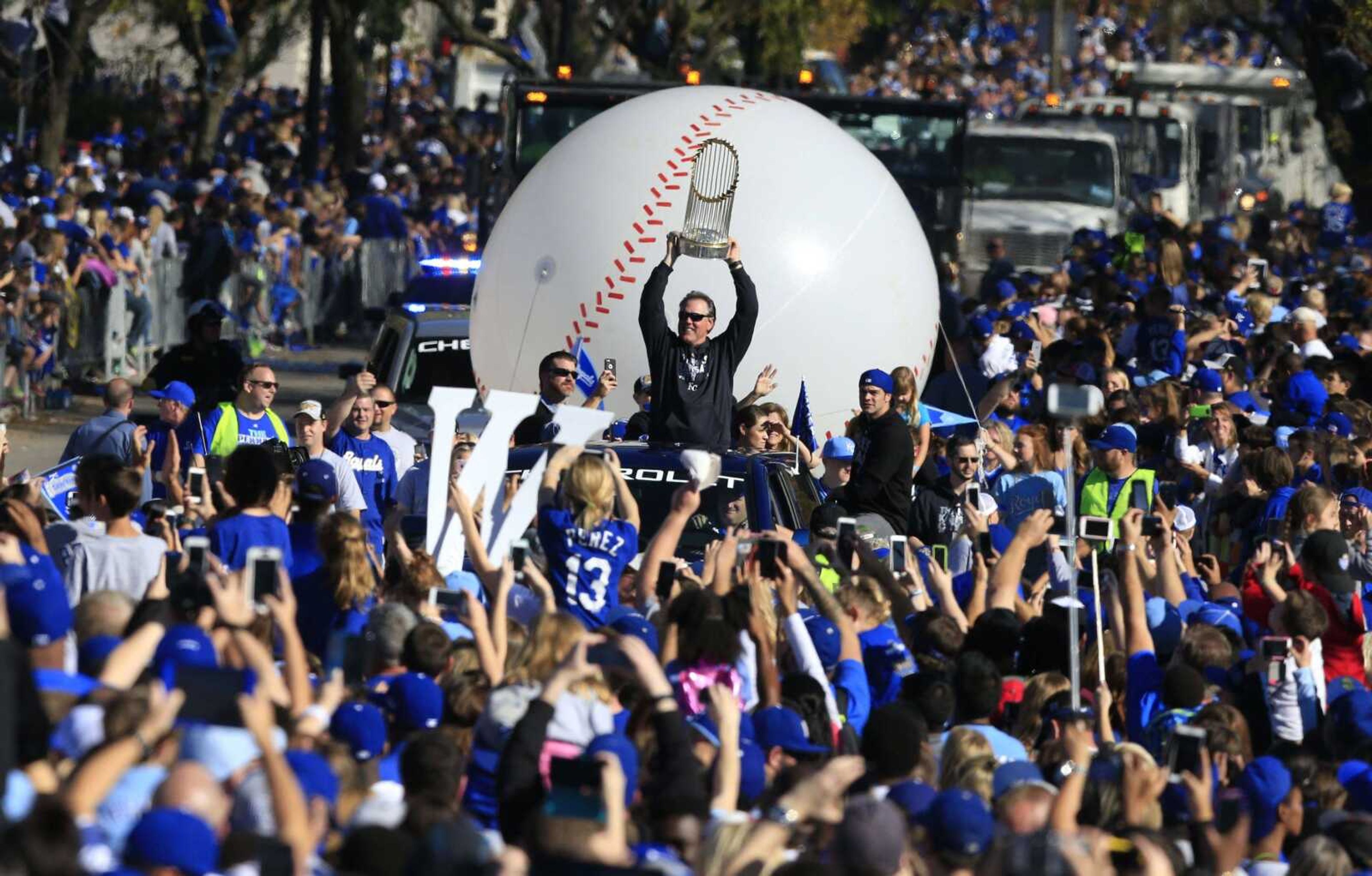 Kansas City Royals manager Ned Yost holds the World Series trophy during the victory parade.