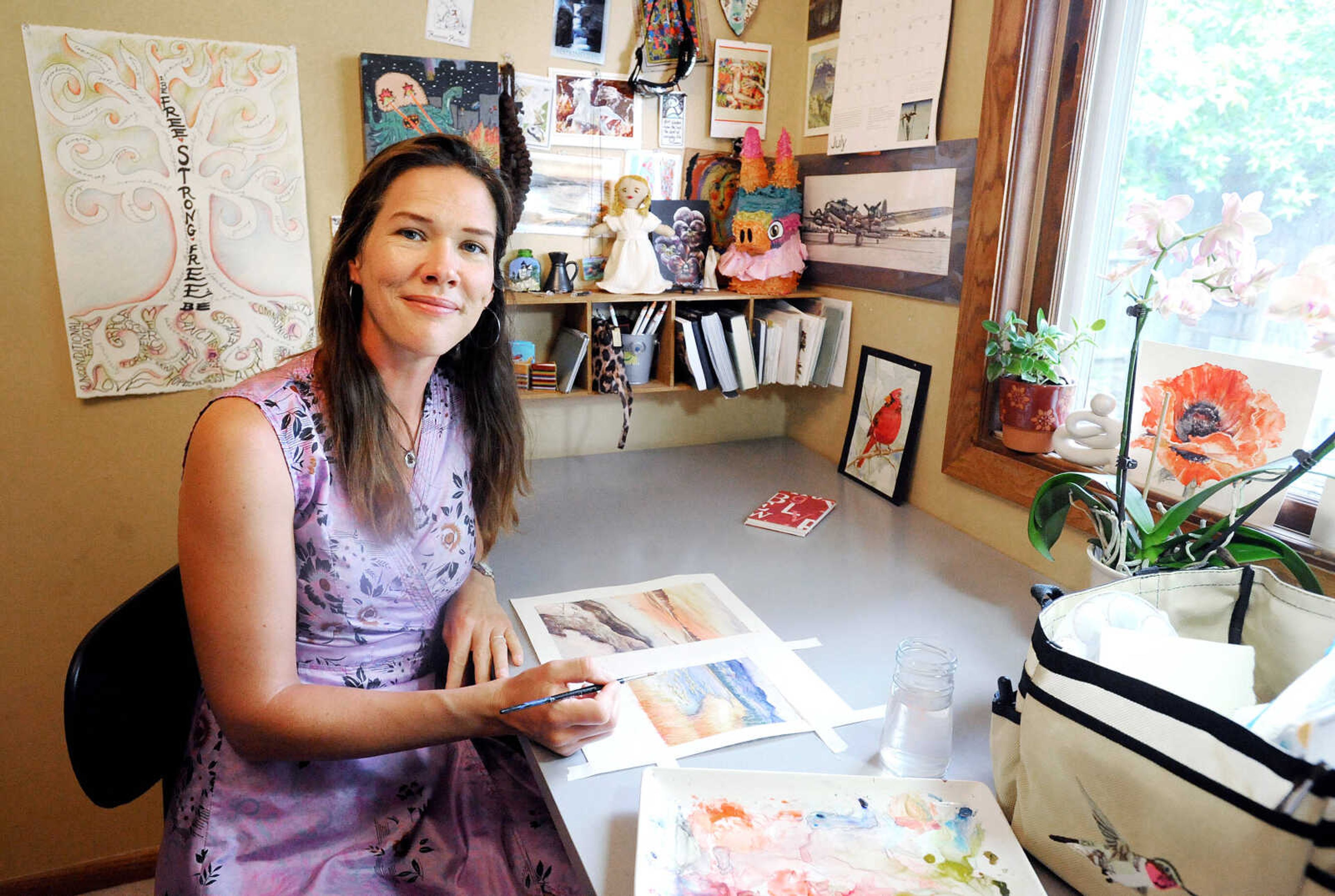 Kelly Hughes works on a watercolor painting inside her Jackson home studio. (Laura Simon)