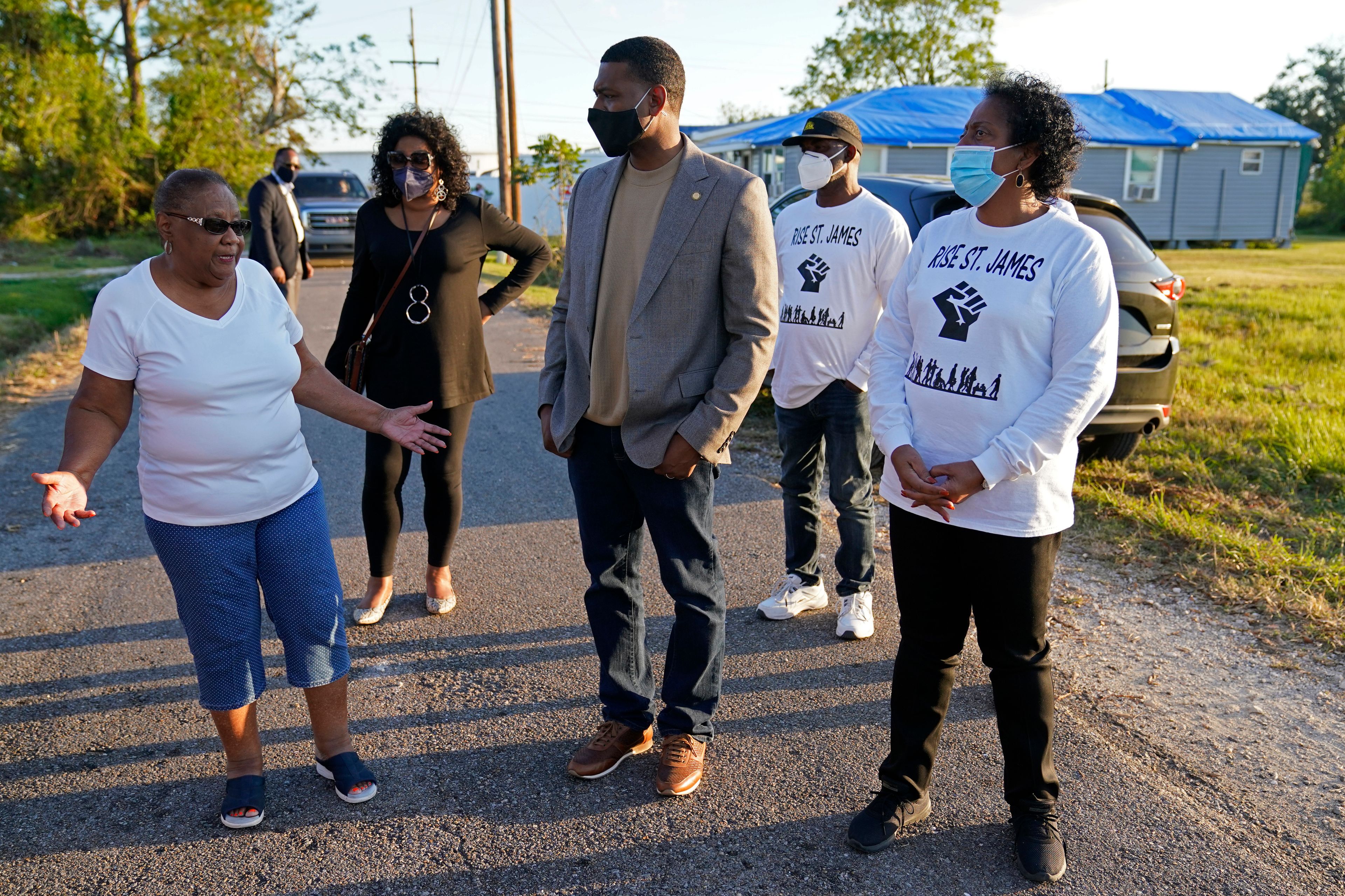 FILE - EPA Administrator Michael Regan talks with Brenda Bryant, left, and other members of the group Rise St. James, as he tours a neighborhood next to the Nu Star Energy oil storage tanks, in St. James Parish, La., on Nov. 16, 2021. (AP Photo/Gerald Herbert, File)