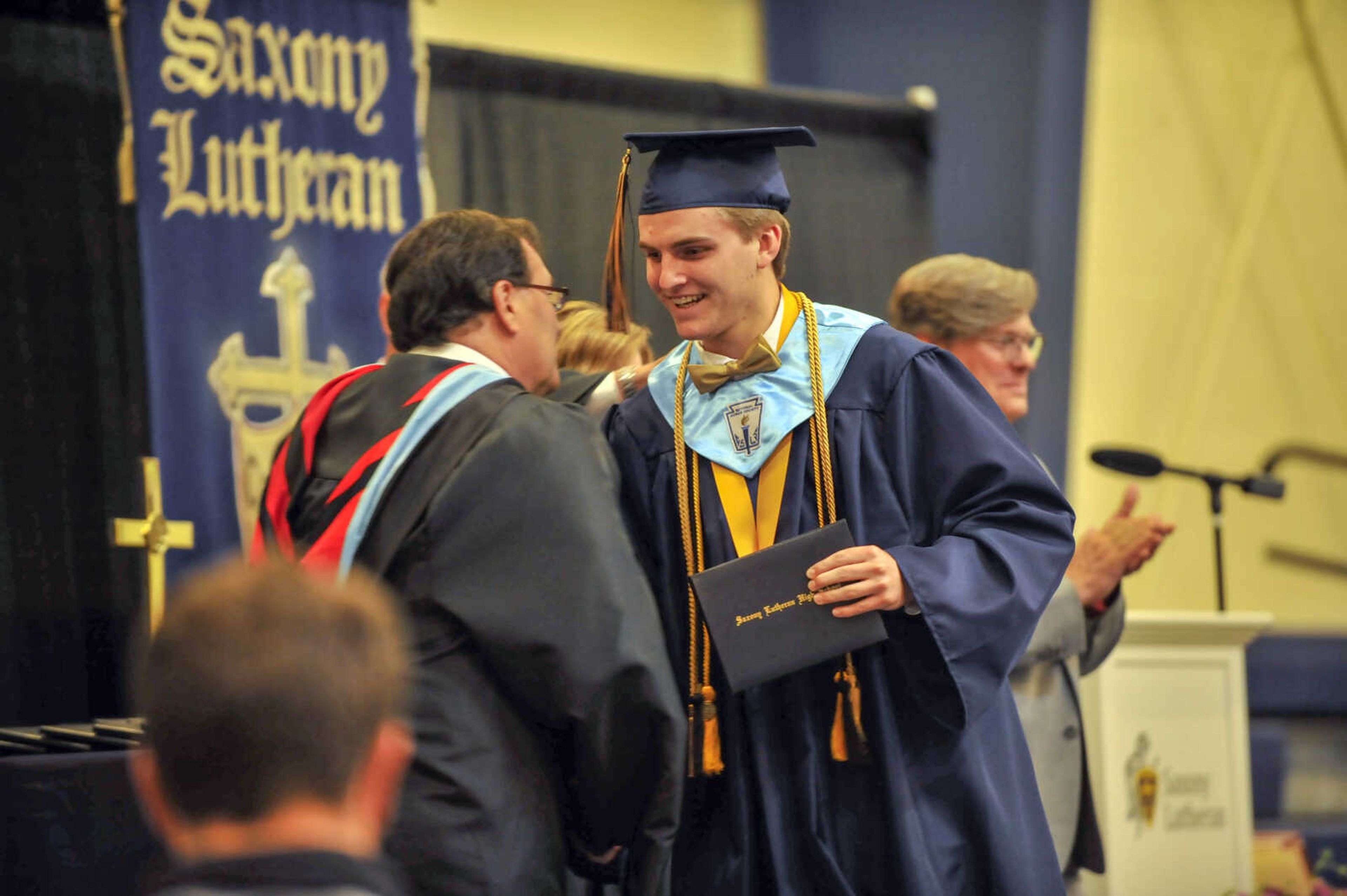 A graduate shakes principal Mark Ruark's hand during commencement at Saxony Lutheran High School on Sunday, May 16, 2021.