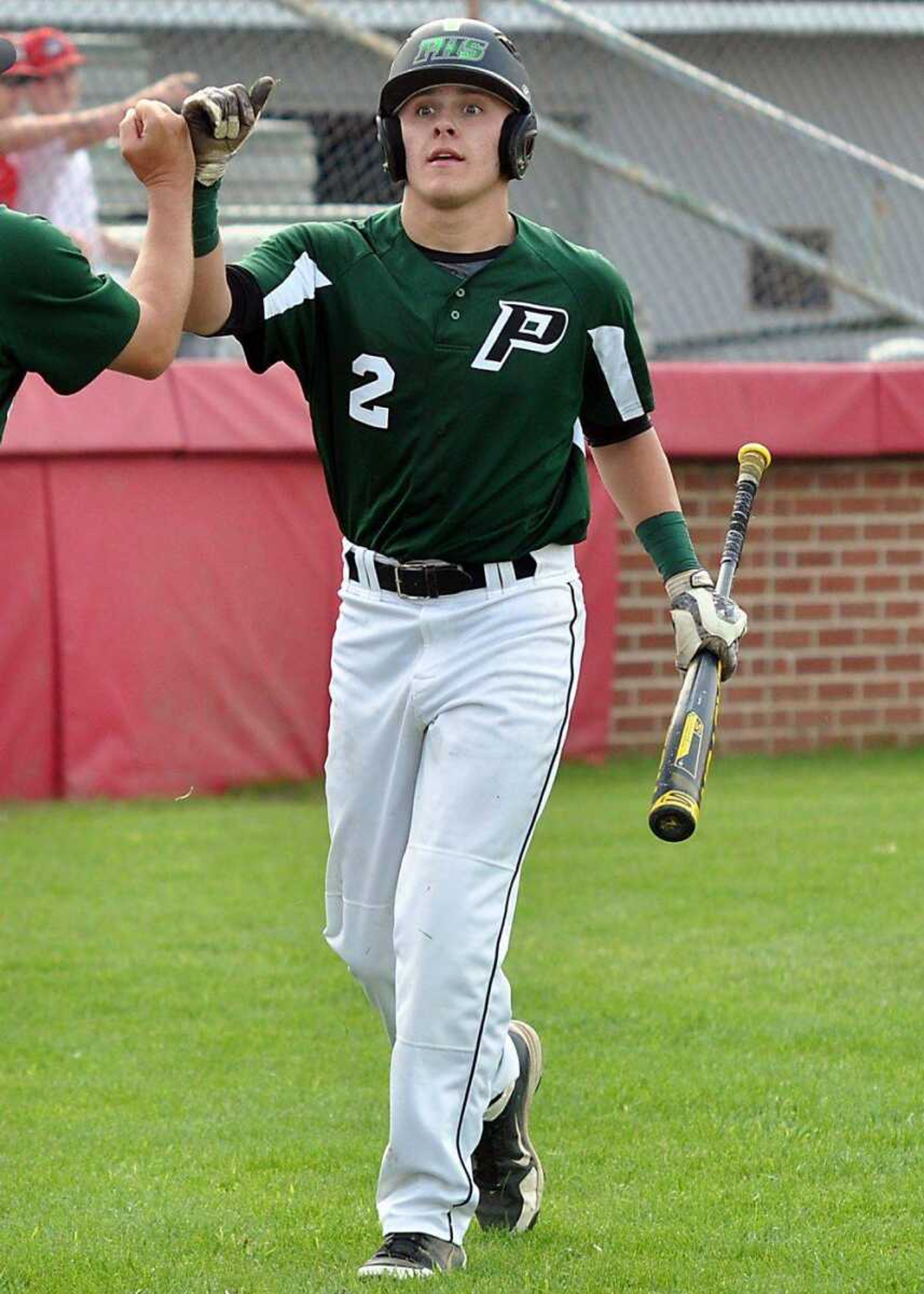 Perryville&#8217;s Tyler Holligan is greeted near the dugout after scoring a run in the bottom of the third inning against Dexter on Monday in Sikeston, Mo. The Pirates advanced to the Class 4 District 1 semifinals with a 7-5 victory. (Dustin Ward ~ Daily Statesman)