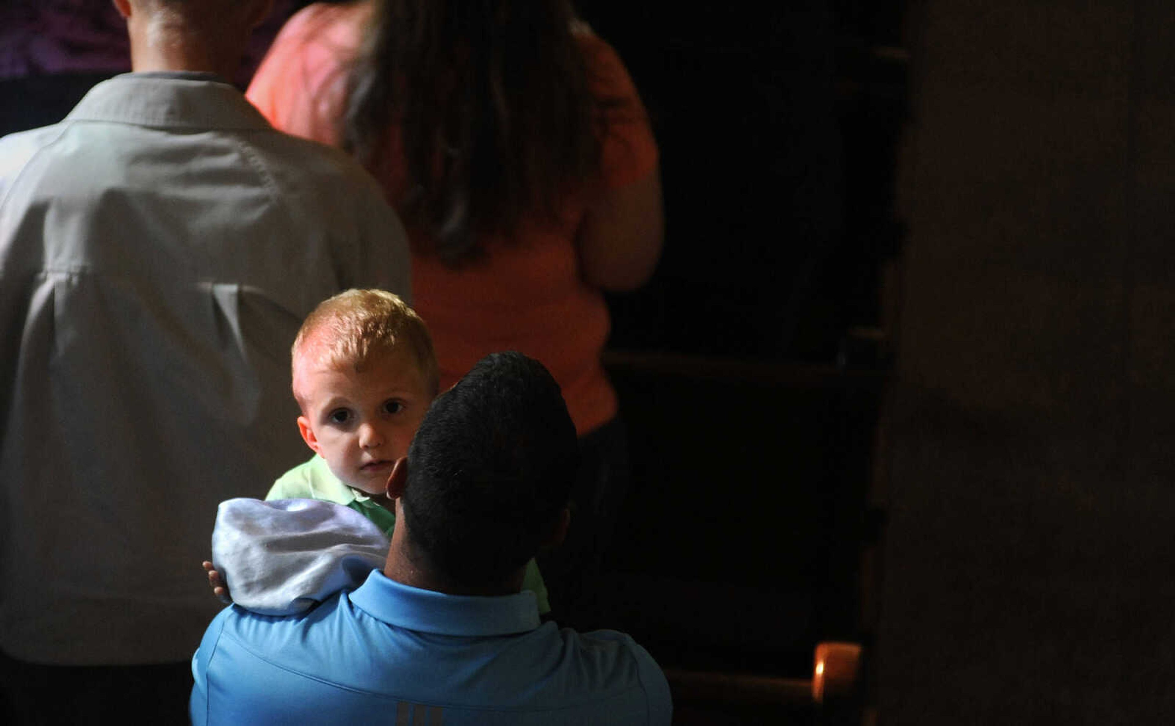 LAURA SIMON ~ lsimon@semissourian.com

A young parishioner looks up from his father's shoulder during the first mass at the newly remodeled St. John's Catholic Church in Leopold, Missouri on Sunday, May 29, 2016.