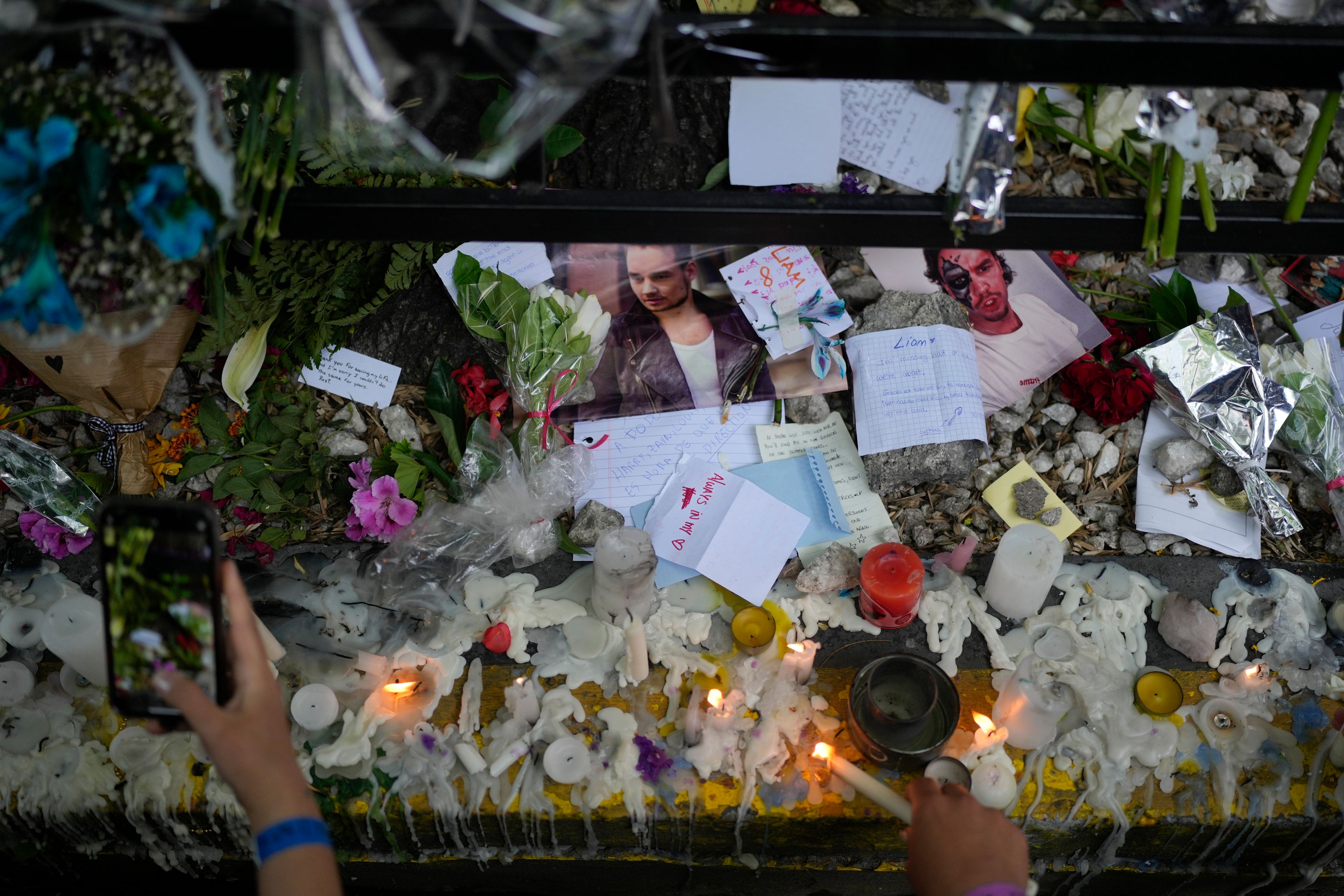 Fans of former One Direction singer Liam create a memorial outside the hotel where he was found dead after falling from a balcony in Buenos Aires, Argentina, Thursday, Oct. 17, 2024. (AP Photo/Natacha Pisarenko)