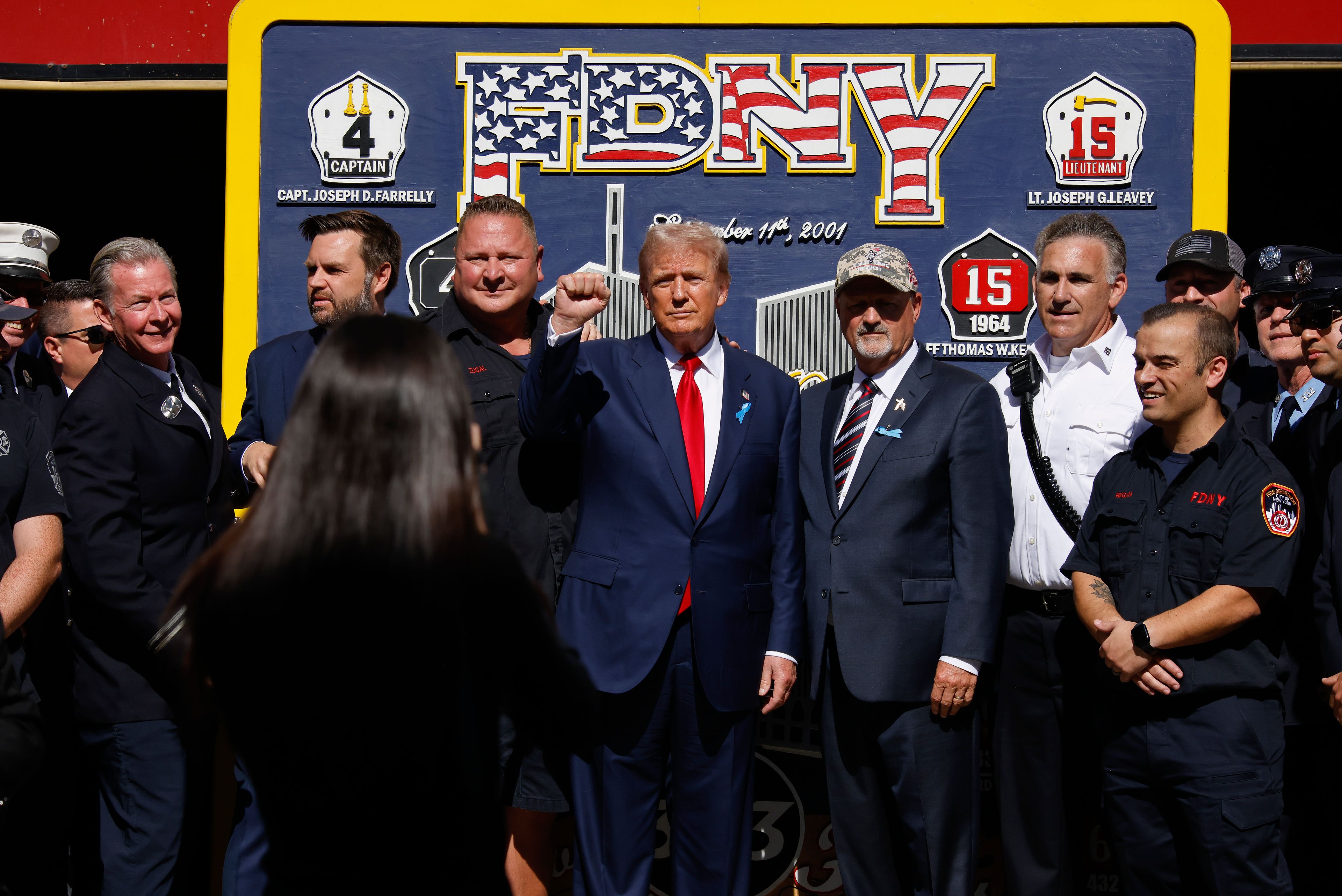 Republican presidential nominee former President Donald Trump, center and Republican vice presidential nominee Sen. JD Vance, R-Ohio, pose for a photo with firefighters from Engine 4 Ladder 15 on the 23rd anniversary of the Sept. 11, 2001 attacks, Wednesday, Sept. 11, 2024, in New York. (AP Photo/Stefan Jeremiah)