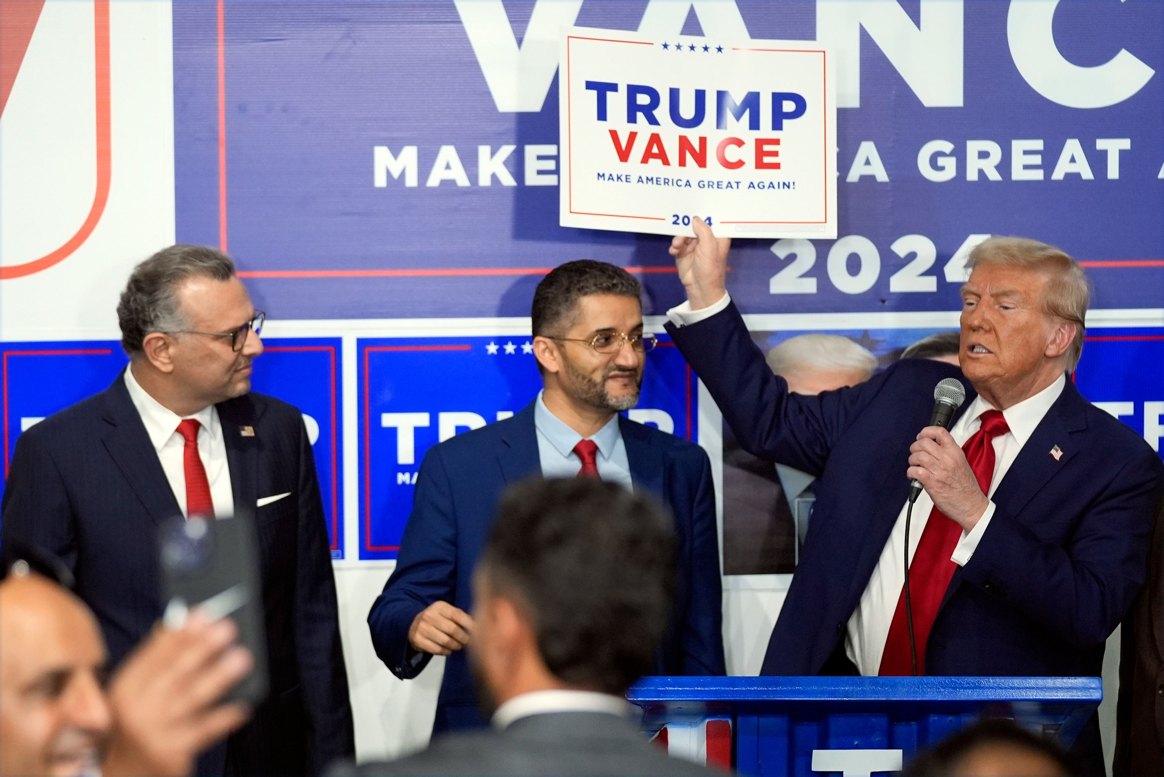 Republican presidential nominee former President Donald Trump speaks as Hamtramck Mayor Amer Ghalib, center, and Massad Boulos, left, listen at a campaign office, Friday, Oct. 18, 2024, in Hamtramck, Mich. (AP Photo/Evan Vucci)