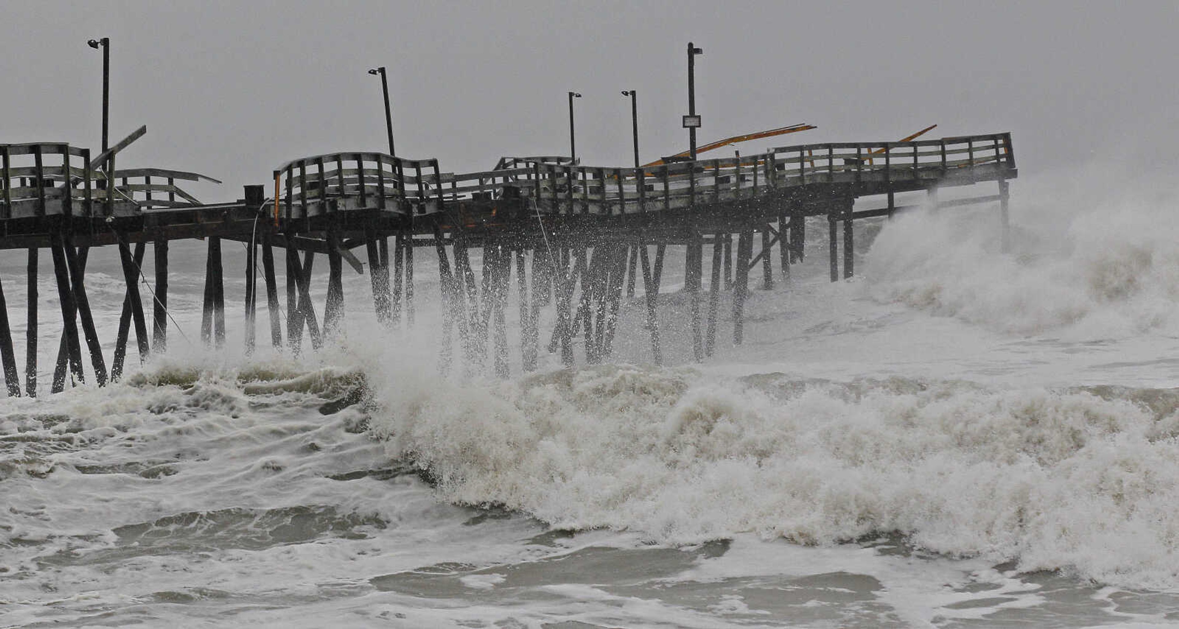 Waves from Hurricane Sandy crash onto the damaged Avalon Pier in Kill Devil Hills, N.C., Monday, Oct. 29, 2012 as Sandy churns up the east coast. Hurricane Sandy continued on its path Monday, as the storm forced the shutdown of mass transit, schools and financial markets, sending coastal residents fleeing, and threatening a dangerous mix of high winds and soaking rain.Ę (AP Photo/Gerry Broome)