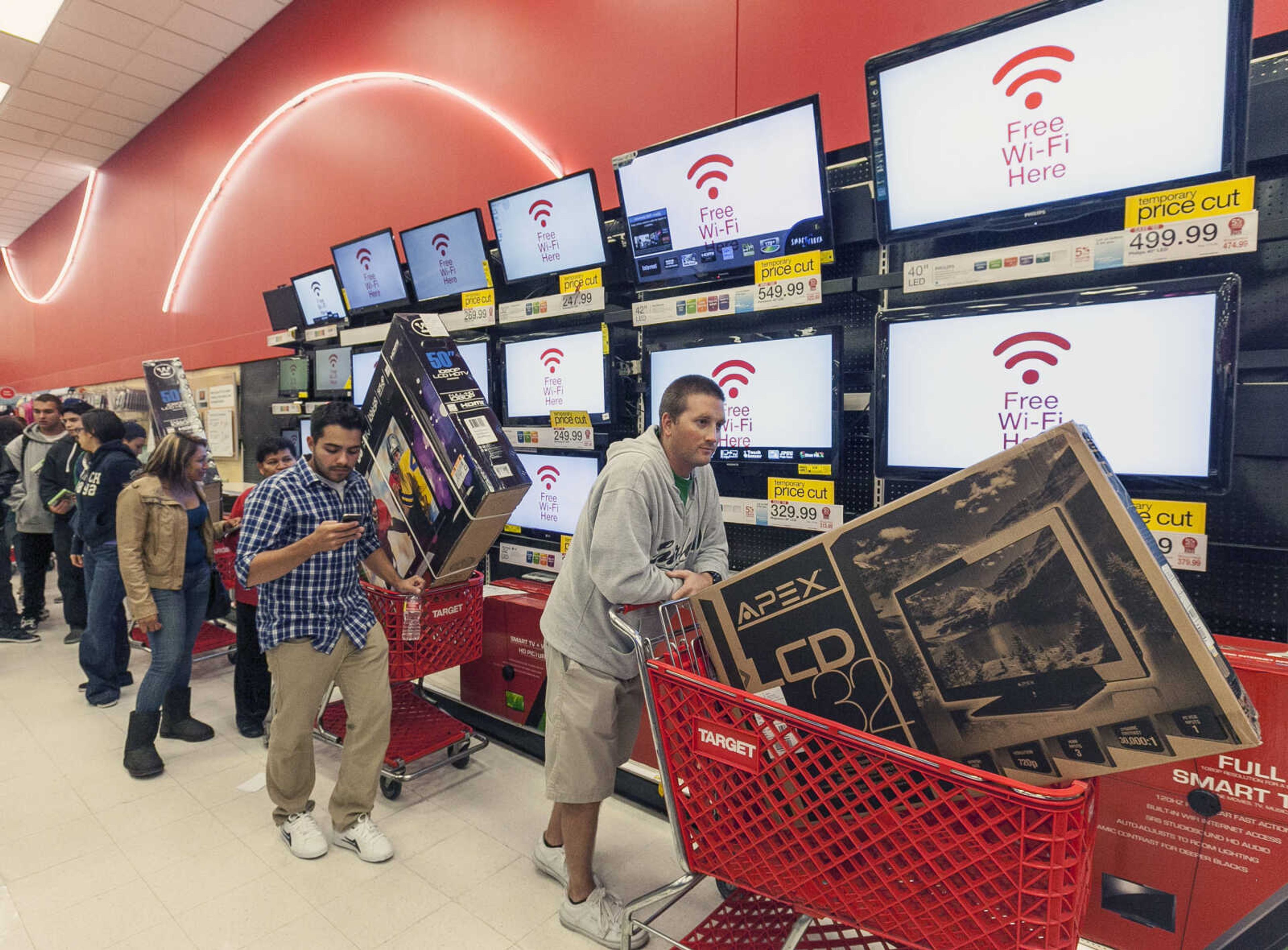 Shoppers use their smart phone with the Free Wi-Fi service, while waiting in line to pay for electronics at the Target store in Burbank, Calif., on Thursday, Nov. 22, 2012. While stores typically open in the wee hours of the morning on the day after Thanksgiving known as Black Friday, openings have crept earlier and earlier over the past few years. Now, stores from Wal-Mart to Toys R Us are opening their doors on Thanksgiving evening, hoping Americans will be willing to shop soon after they finish their pumpkin pie. (AP Photo/Damian Dovarganes)