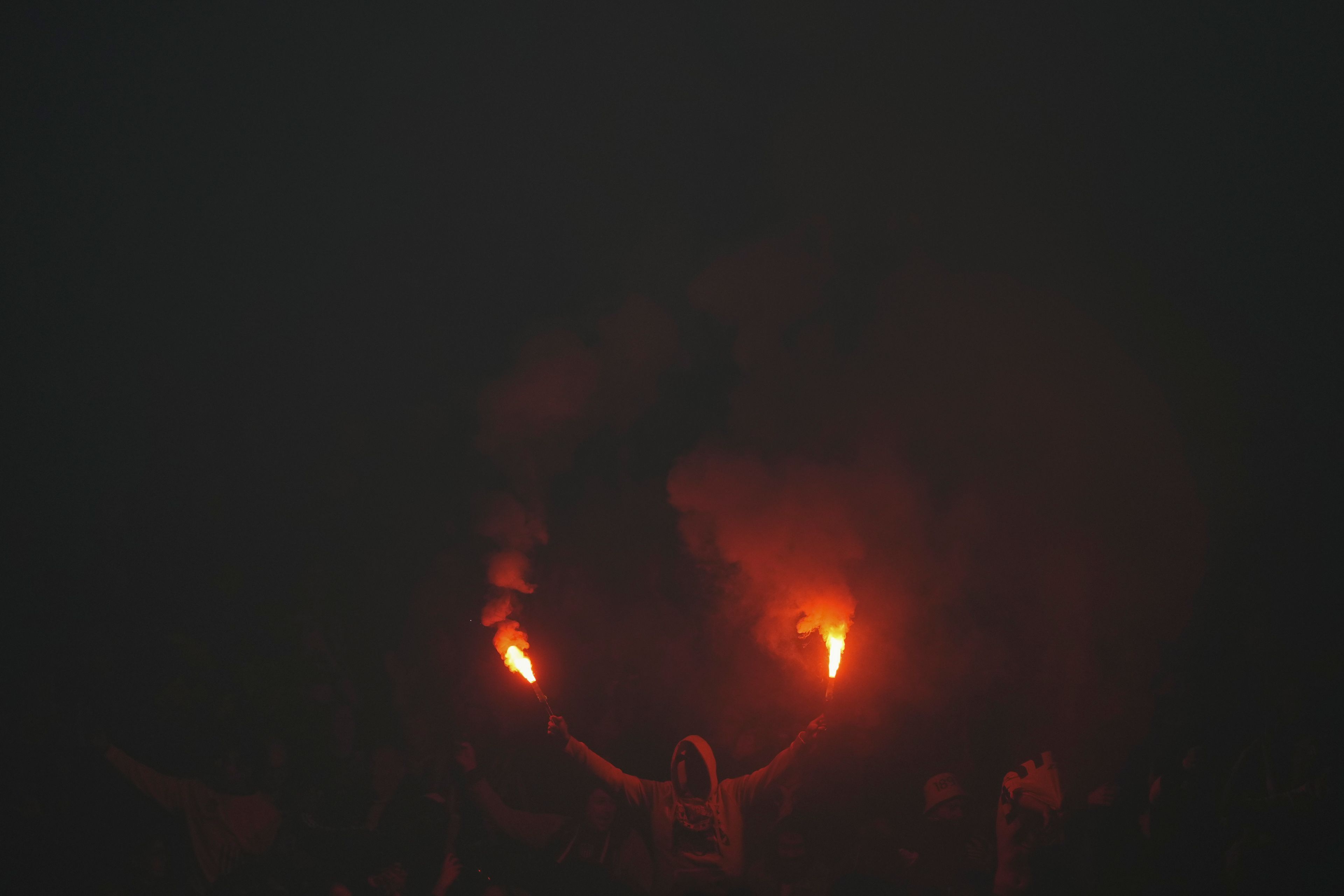 A Uruguay Penarol fan holds flares prior to a Copa Libertadores soccer match against Brazil's Flamengo at Campeon del Siglo Stadium in Montevideo, Uruguay, Thursday, Sept. 26, 2024. (AP Photo/Matilde Campodonico)