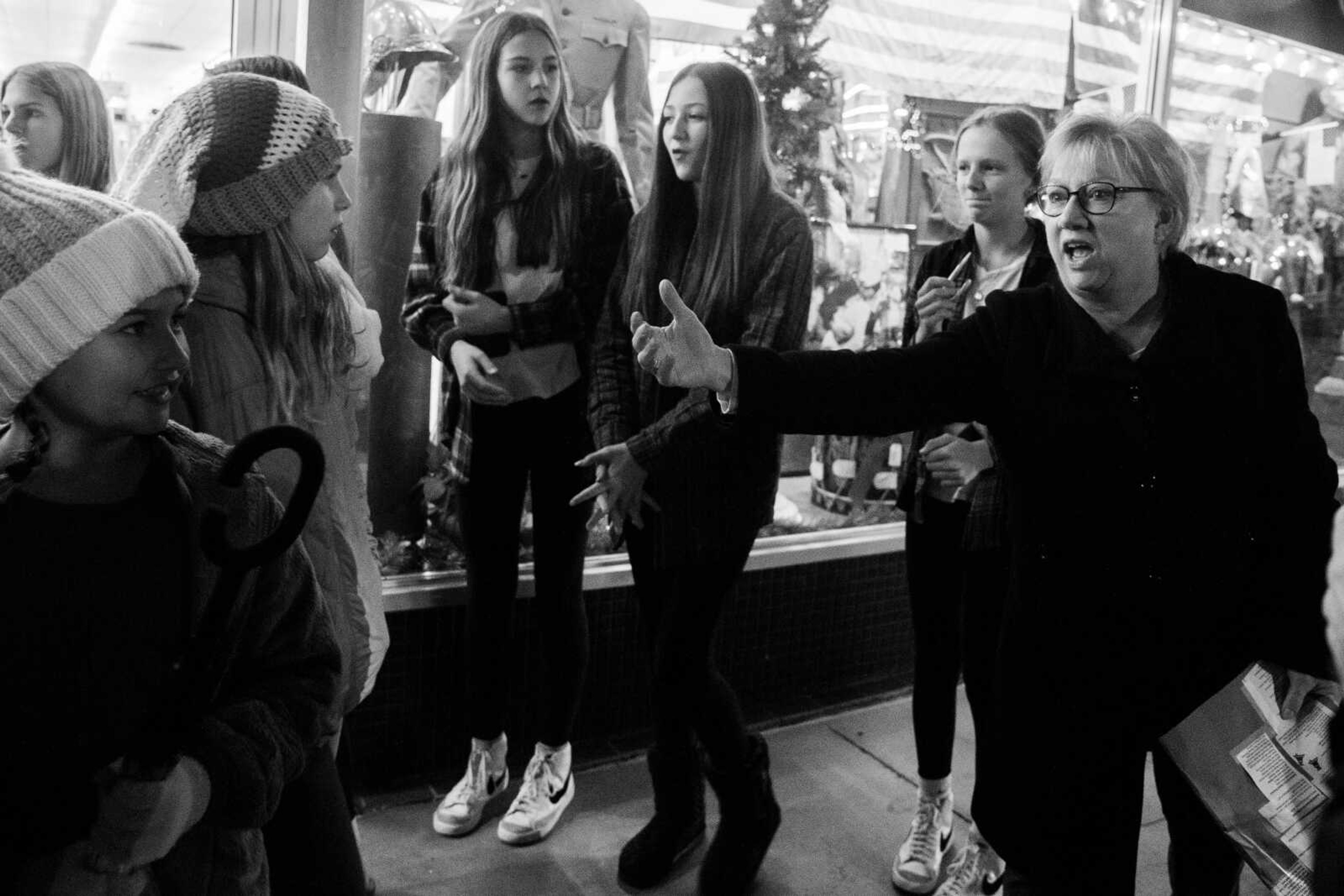 Rebecca Gentry motions for students to follow her as the choir carols for downtown businesses&nbsp;on Friday, Dec. 2 in downtown Cape Girardeau.