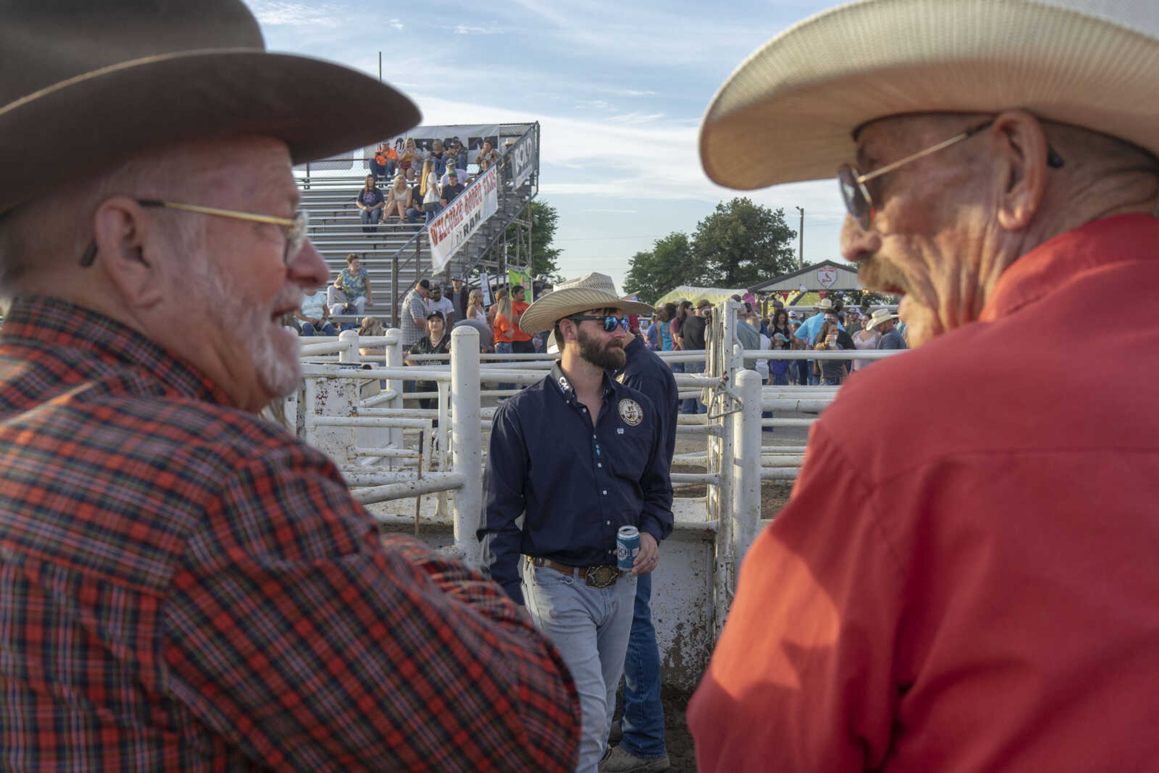 Robbie Marshall, center, watches over livestock in the roping box as Gaylon Bryeans, left and Bruce Raepert converse during the last night of the Sikeston Jaycees Bootheel Rodeo Saturday, Aug. 14, 2021,&nbsp;in Sikeston, Missouri. This year Raepert said, would be his 64th attending the rodeo, having attended his first at five years old. Bryeans, who attended with his granddaughter (not pictured) said he's been coming since 1959, when he was six.