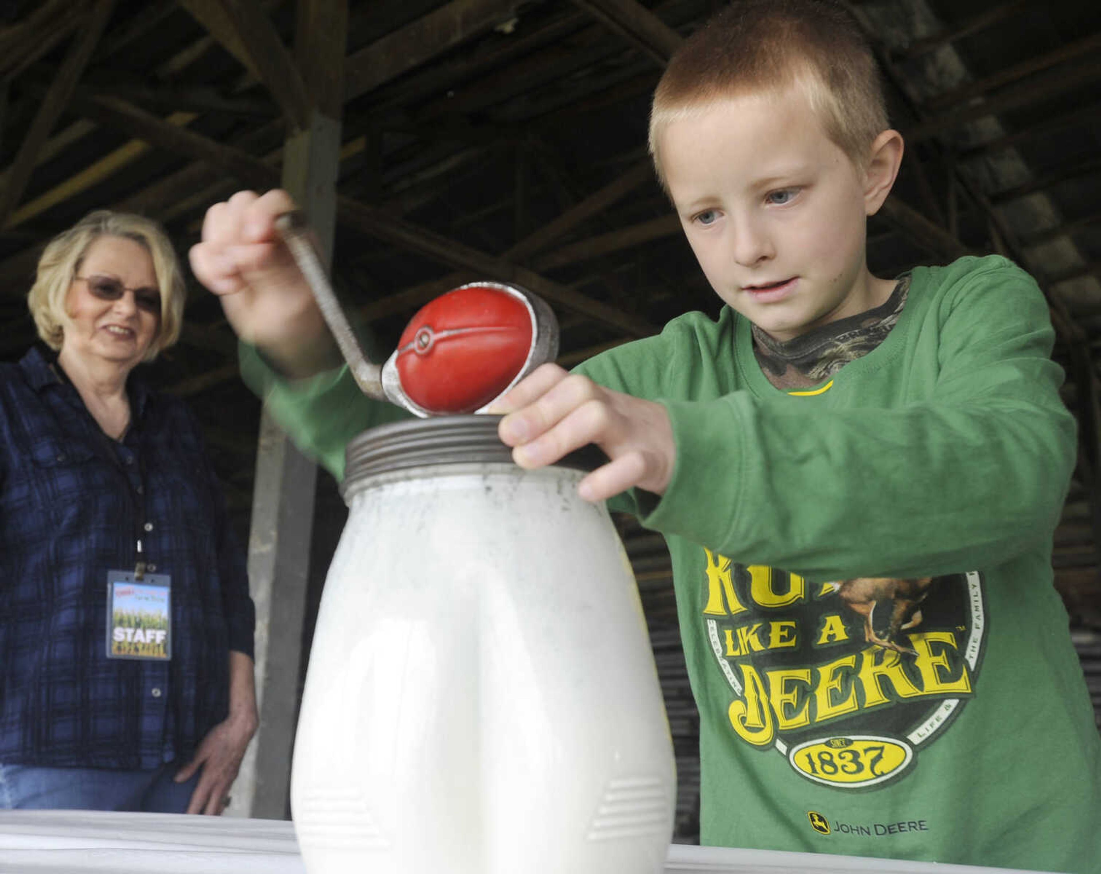 FRED LYNCH ~ flynch@semissourian.com
Zach Eftink of Chaffee, Missouri takes a turn with the butter churn, as Shirley Kay Davis looks on, at the Cousin Carl Farm Show on Saturday, March 12, 2016 at Arena Park.