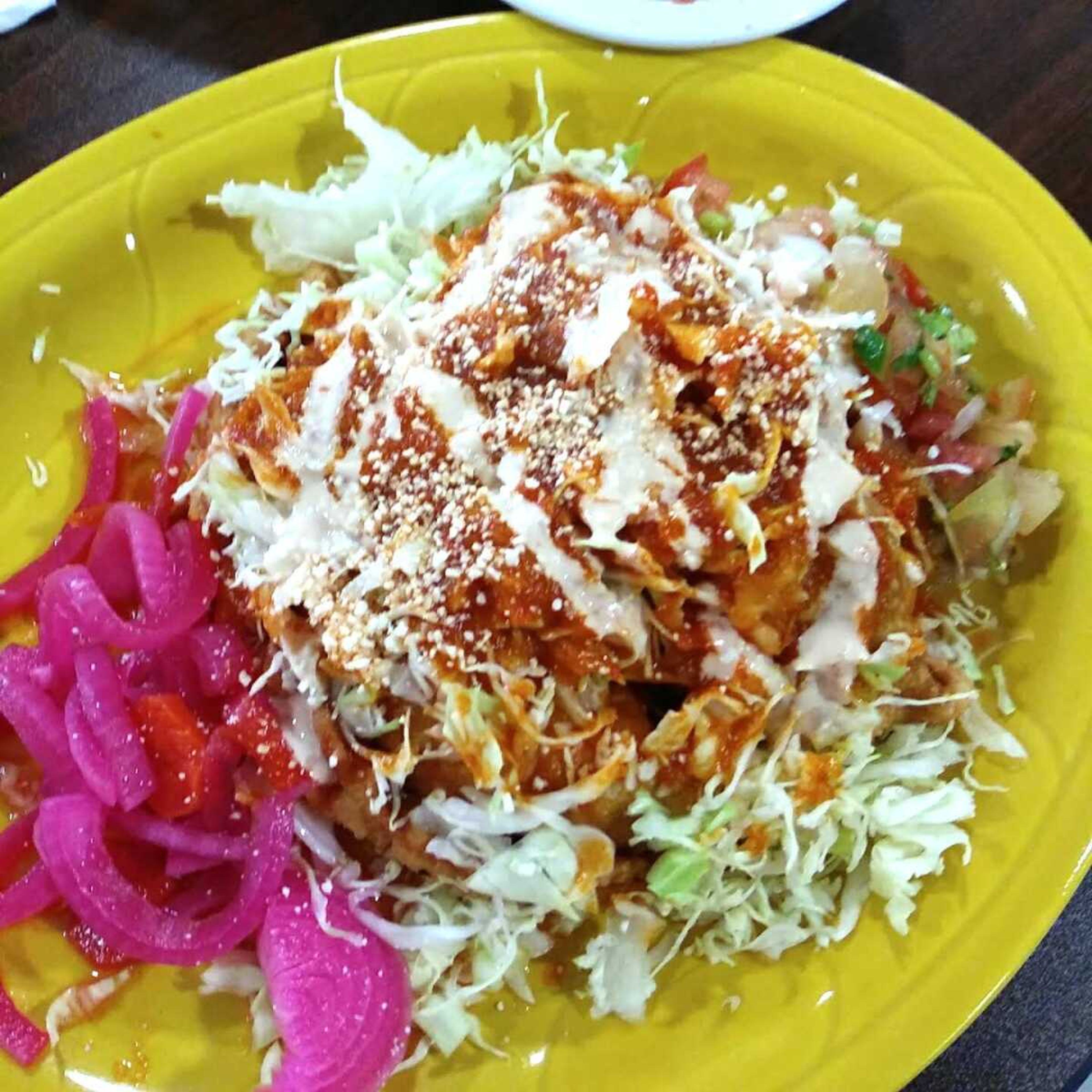 Hidden under all of that cabbage and sauce are two Pastelitos de Harina, one fried pastry full of beef and rice, and the other full of chicken.