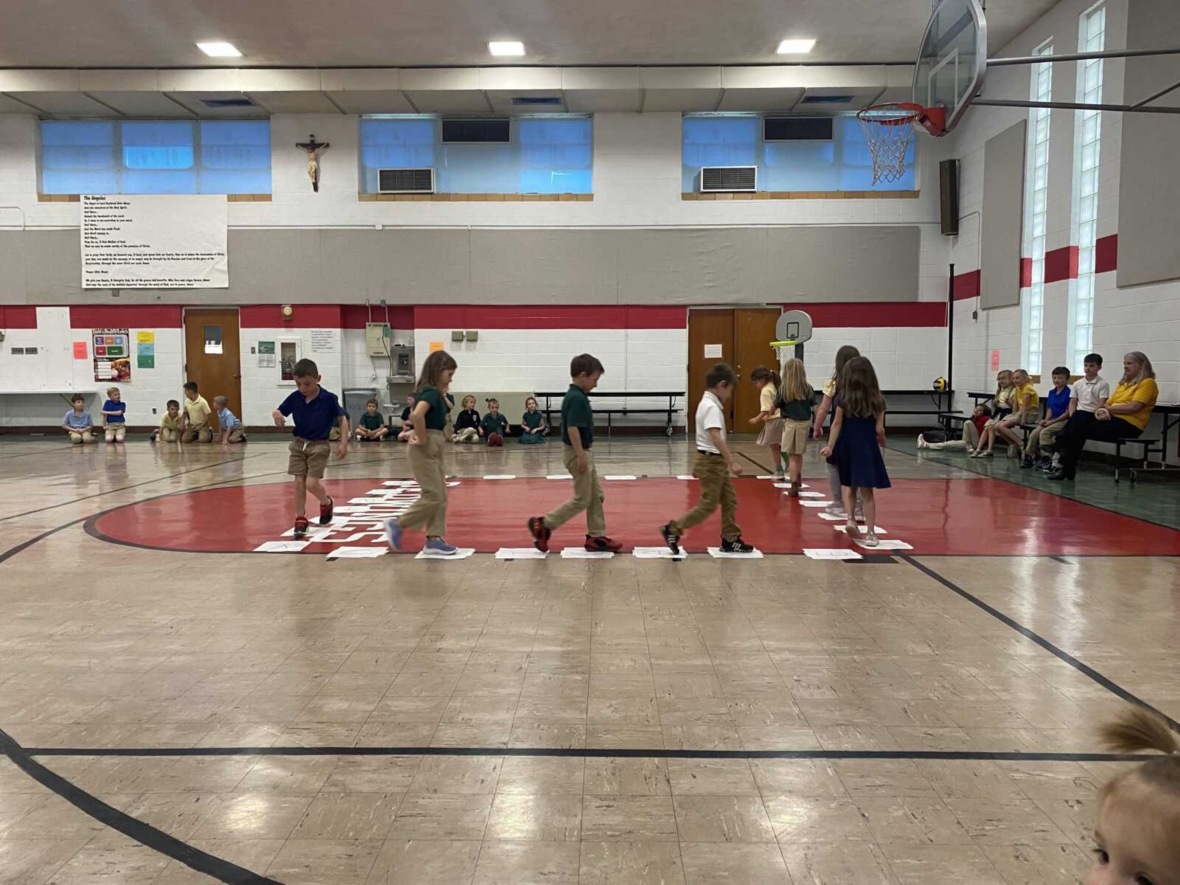 
The kindergarten class takes their turn at walking on the cake walk.  Music is played, and when it stops, each student stops on the letter they end up on.  Someone will pull a letter from the pile to determine who the winner will be.