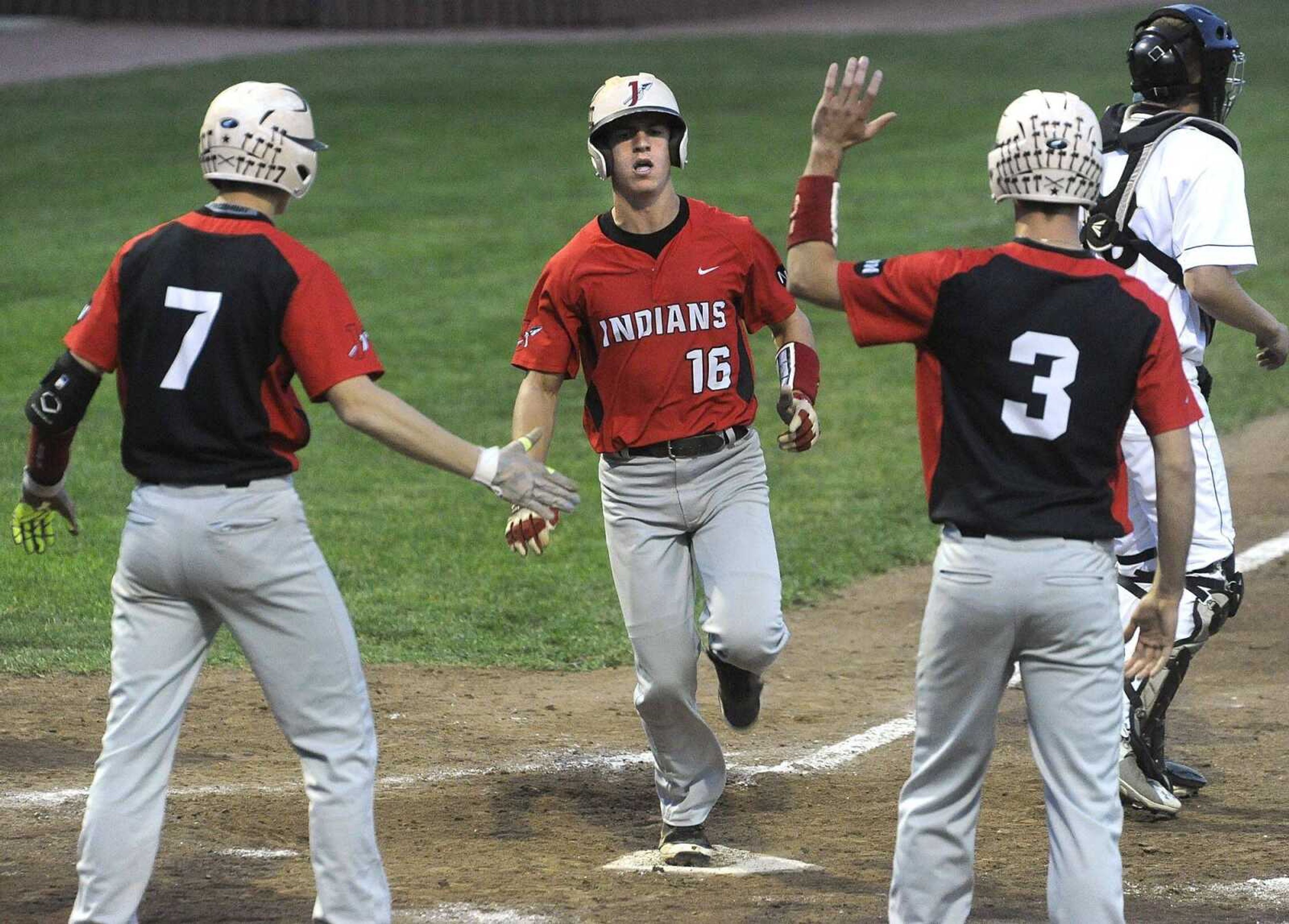 Jackson's Ben Maudie is congratulated by Wyatt Eldridge, left, and Cameron Duke while scoring on a hit by Jarrett Newell against Farmington during the fifth inning of a Class 5 District 1 semifinal Tuesday, May 19, 2015 in Farmington, Missouri. (Fred Lynch)