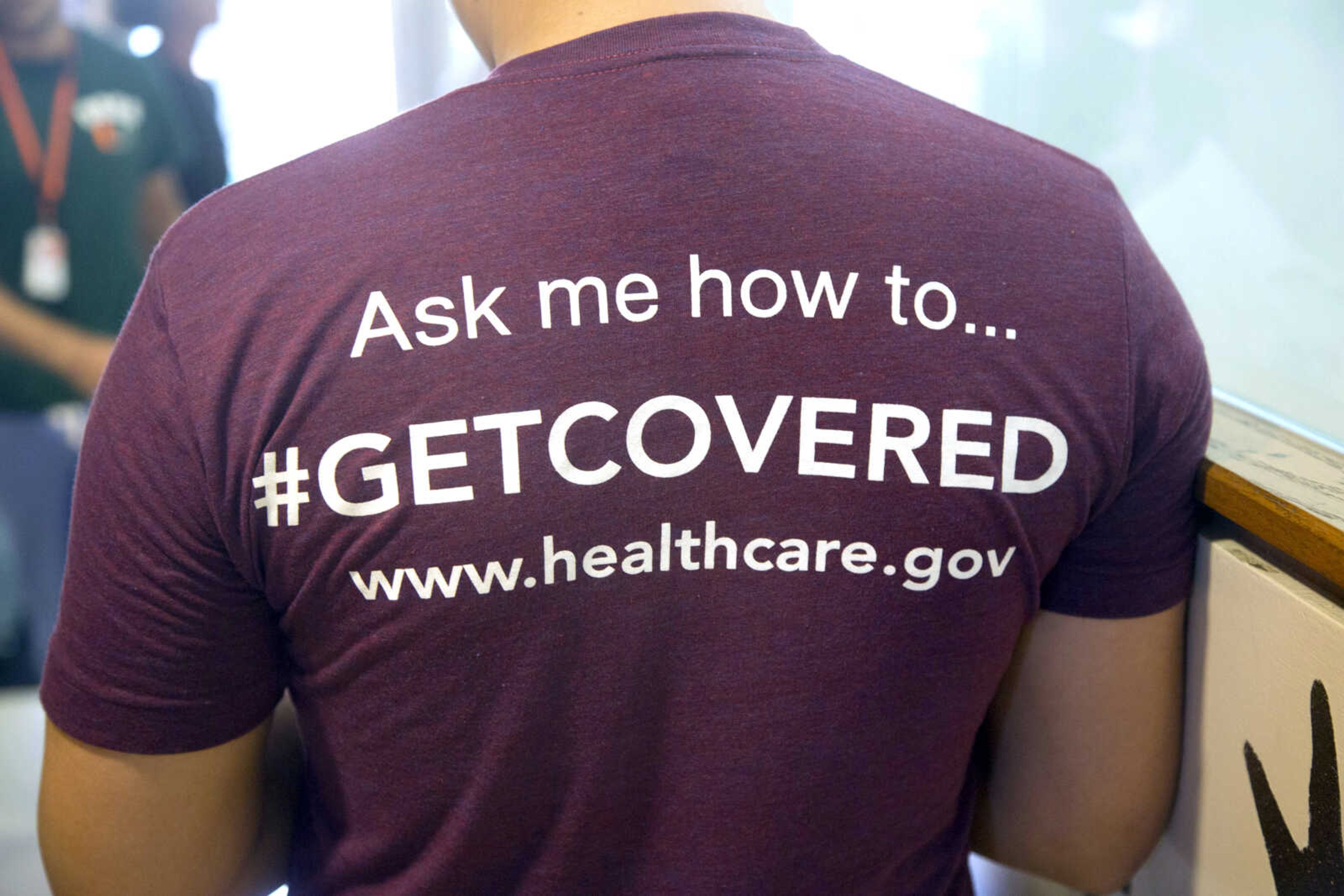 A volunteer health-care worker wears a T-shirt urging people to sign up for the new health-care programs March 15, 2014, in Miami.