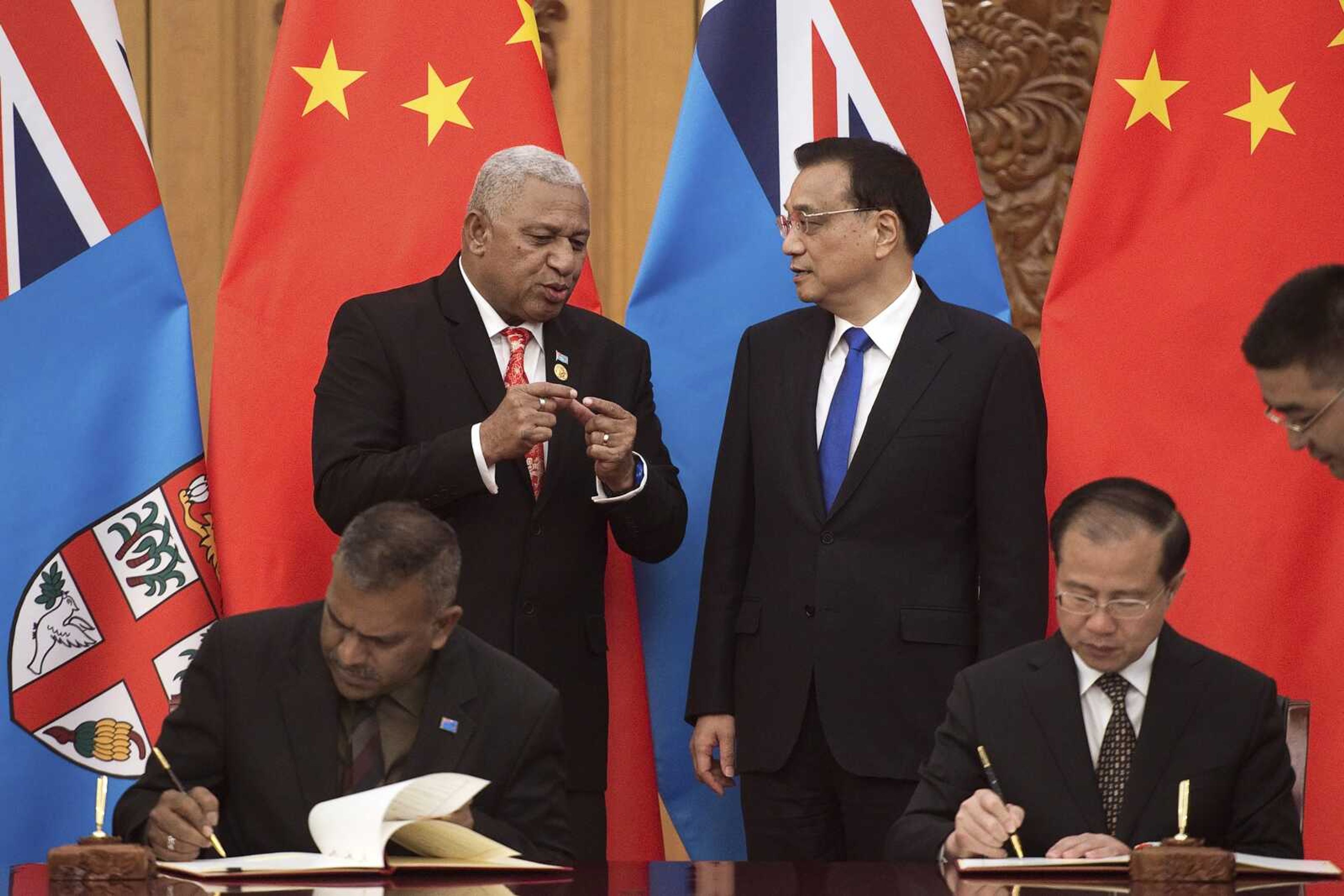 Fiji's Prime Minister Prime Minister Frank Bainimarama, top left, talks with Chinese Premier Li Keqiang, top right, during a signing ceremony between the two countries at the Great Hall of the People on May 16, 2107, in Beijing.