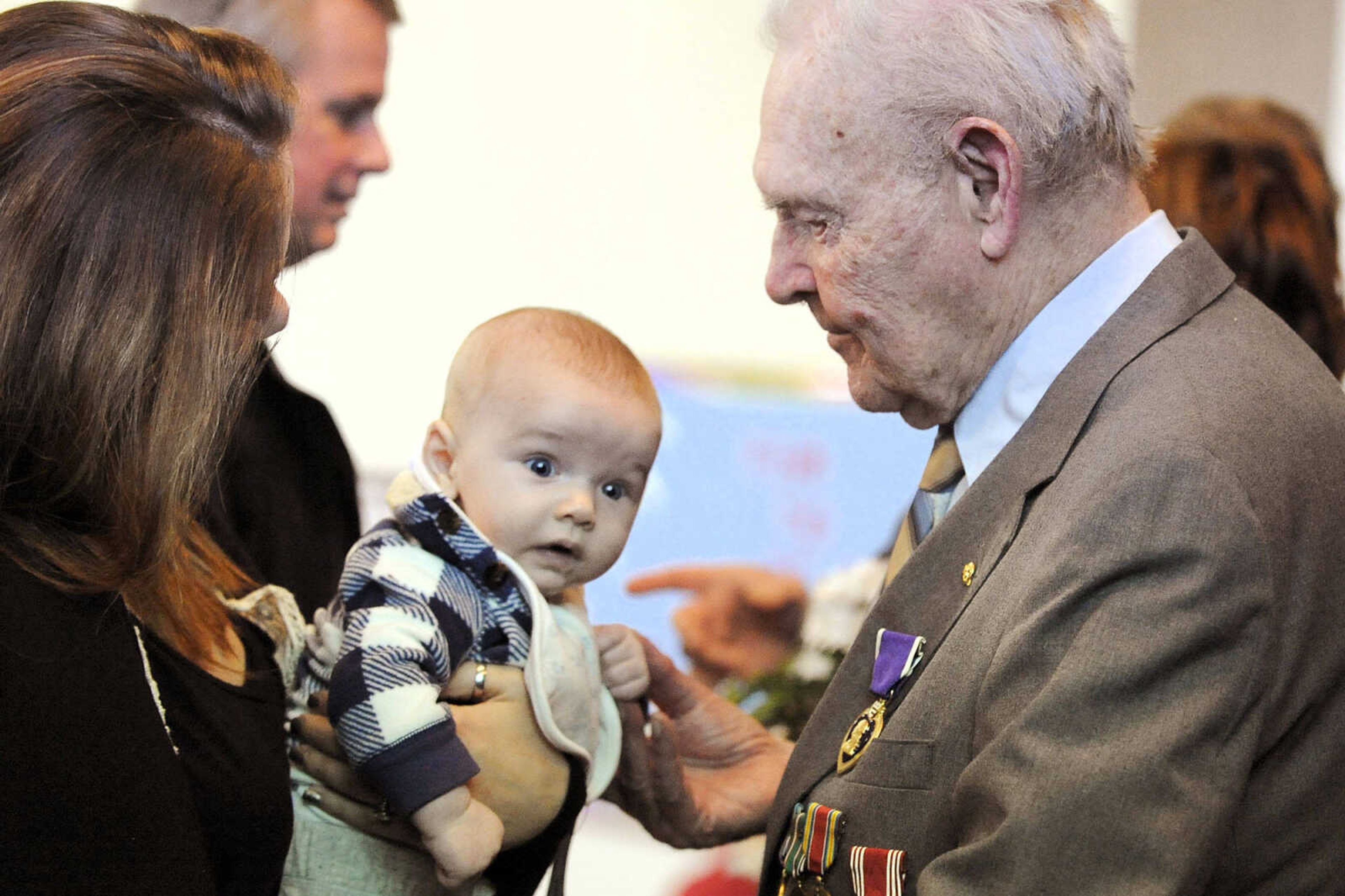 LAURA SIMON ~ lsimon@semissourian.com

Sgt. Clifford Heinrich visits with three-month-old John Casen Rogers and his mother, and Heinrich's caretaker of seven years,  Bailey, on Monday, March 21, 2016, during the living history event honoring the WWII lost crew of the Flying Fortress 812, and the medal presentation to Sgt. Clifford Heinrich at Alma Schrader Elementary. Heinrich was presented with an American Campaign Medal, WWII Victory Medal, Army Good Conduct Medal, a WWII Lapel Button, European-African-Middle Eastern Campaign Medal and the Purple Heart for his service during WWII during Monday's presentation.