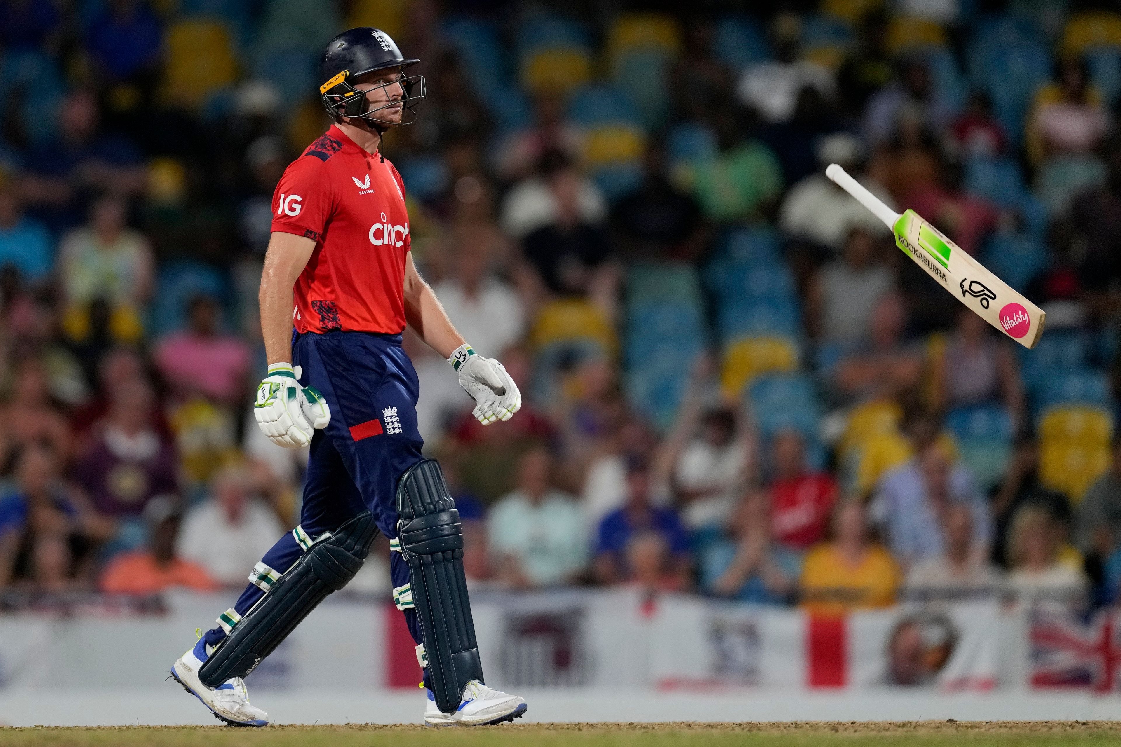 England's captain Jos Buttler throws his bat as he walks off the field, caught by West Indies' captain Rovman Powell for 83 runs, during the second T20 cricket match at Kensington Oval in Bridgetown, Barbados, Sunday, Nov. 10, 2024. (AP Photo/Ricardo Mazalan)