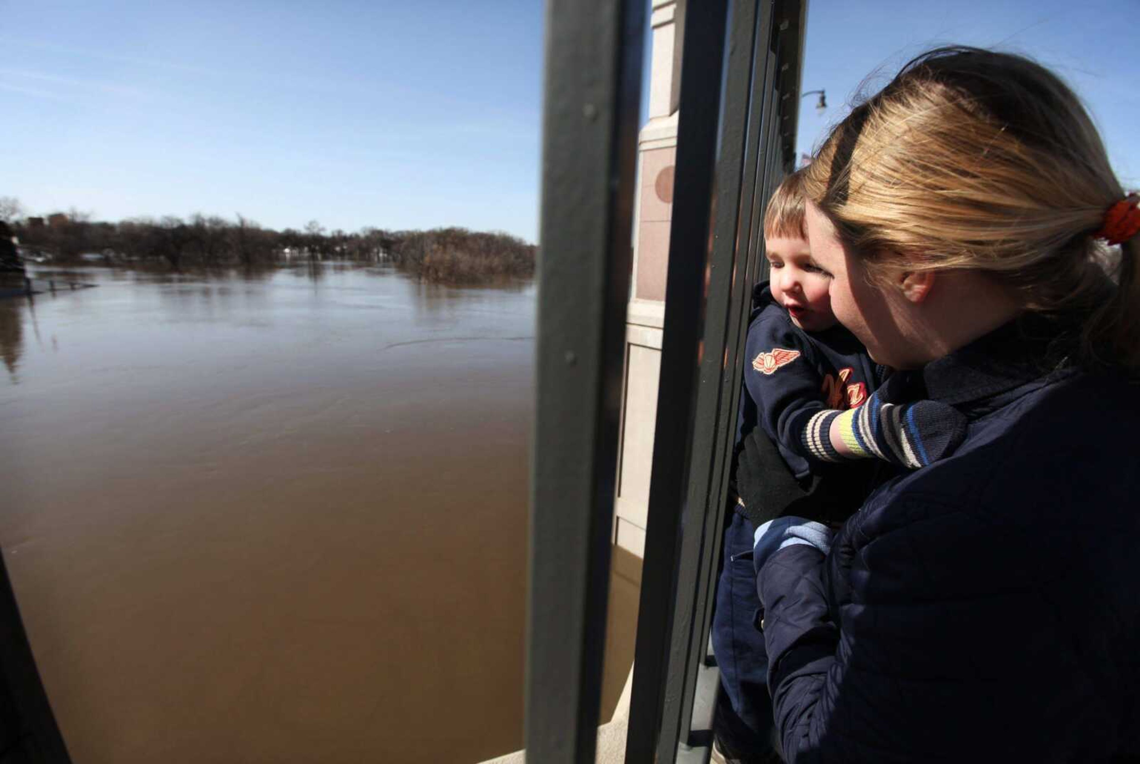 Evan Nichols, 2, hangs on to his mom, Melanie, while they observe the Red River on Veterans Memorial Bridge in Moorhead, Minn. on Sunday, March 21, 2010. The Red River has crested at just under 37 feet. (AP Photo/Jay Pickthorn)