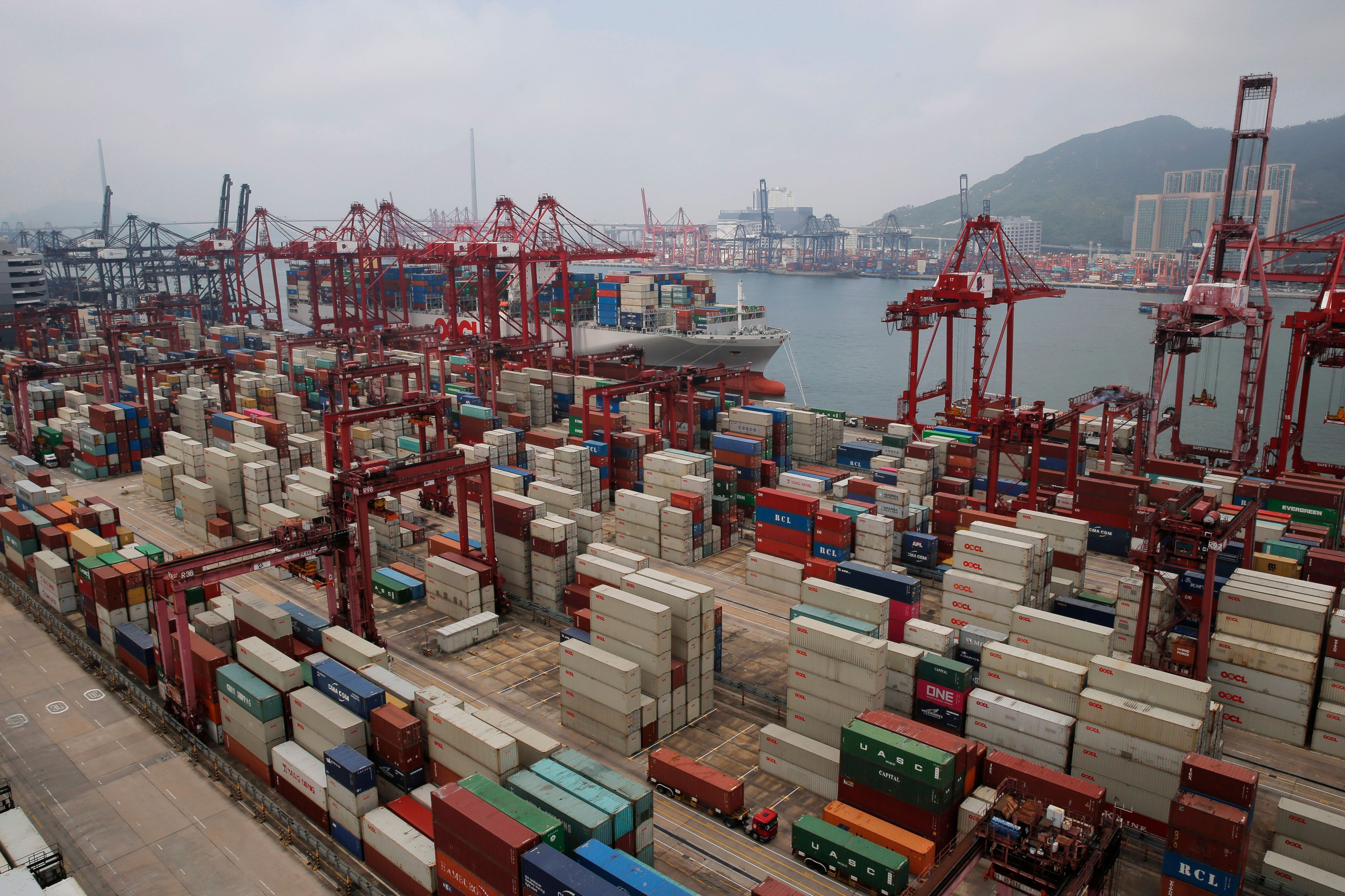 FILE - Gantry cranes load cargo onto container ships at a port of Kwai Tsing Container Terminals in Hong Kong, Friday, May 24, 2019. (AP Photo/Kin Cheung, File)