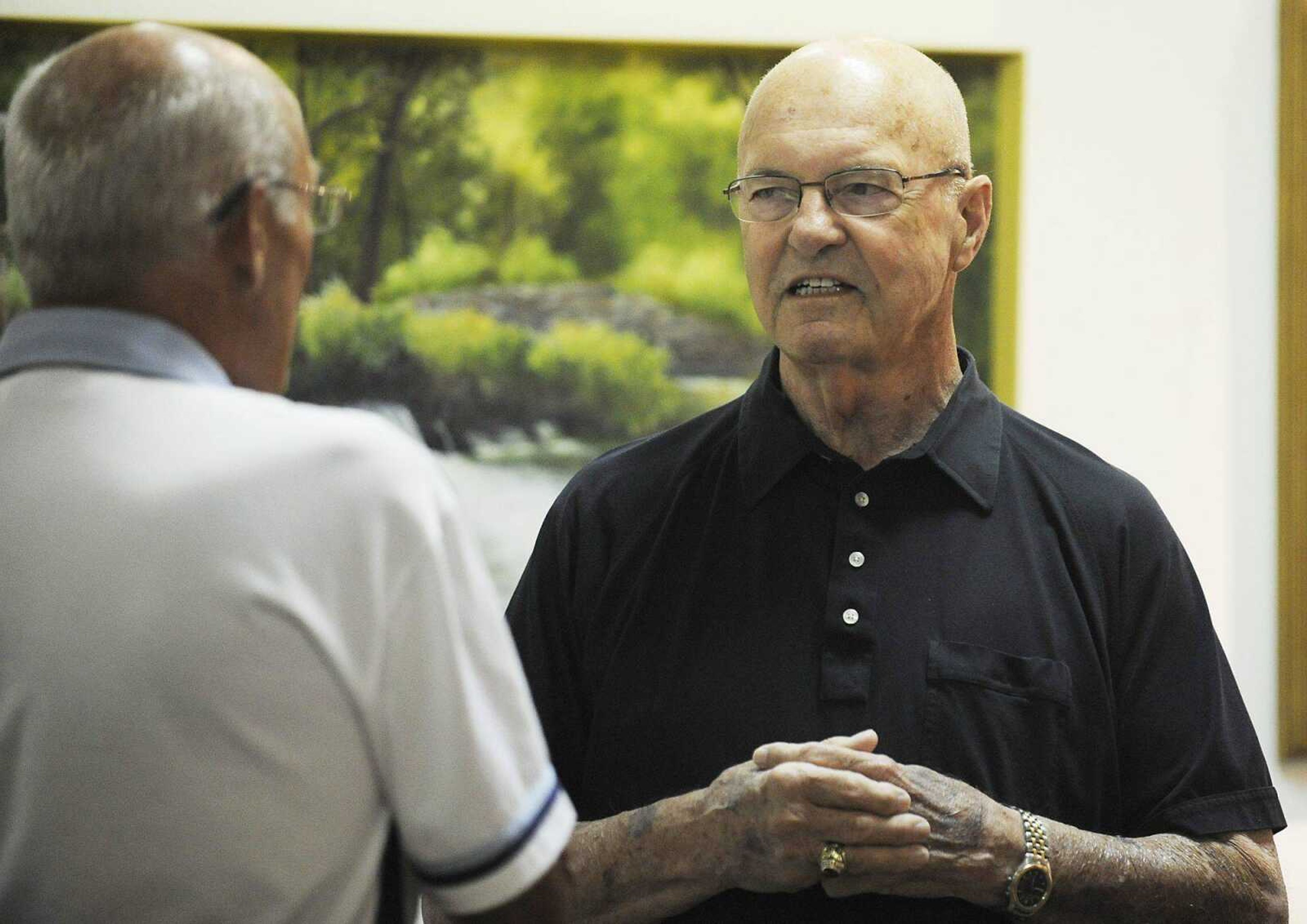 Herb Wickham, right, talks about some of his paintings during a show of his work July 5 at the Arts Council of Southeast Missouri. (Adam Vogler)