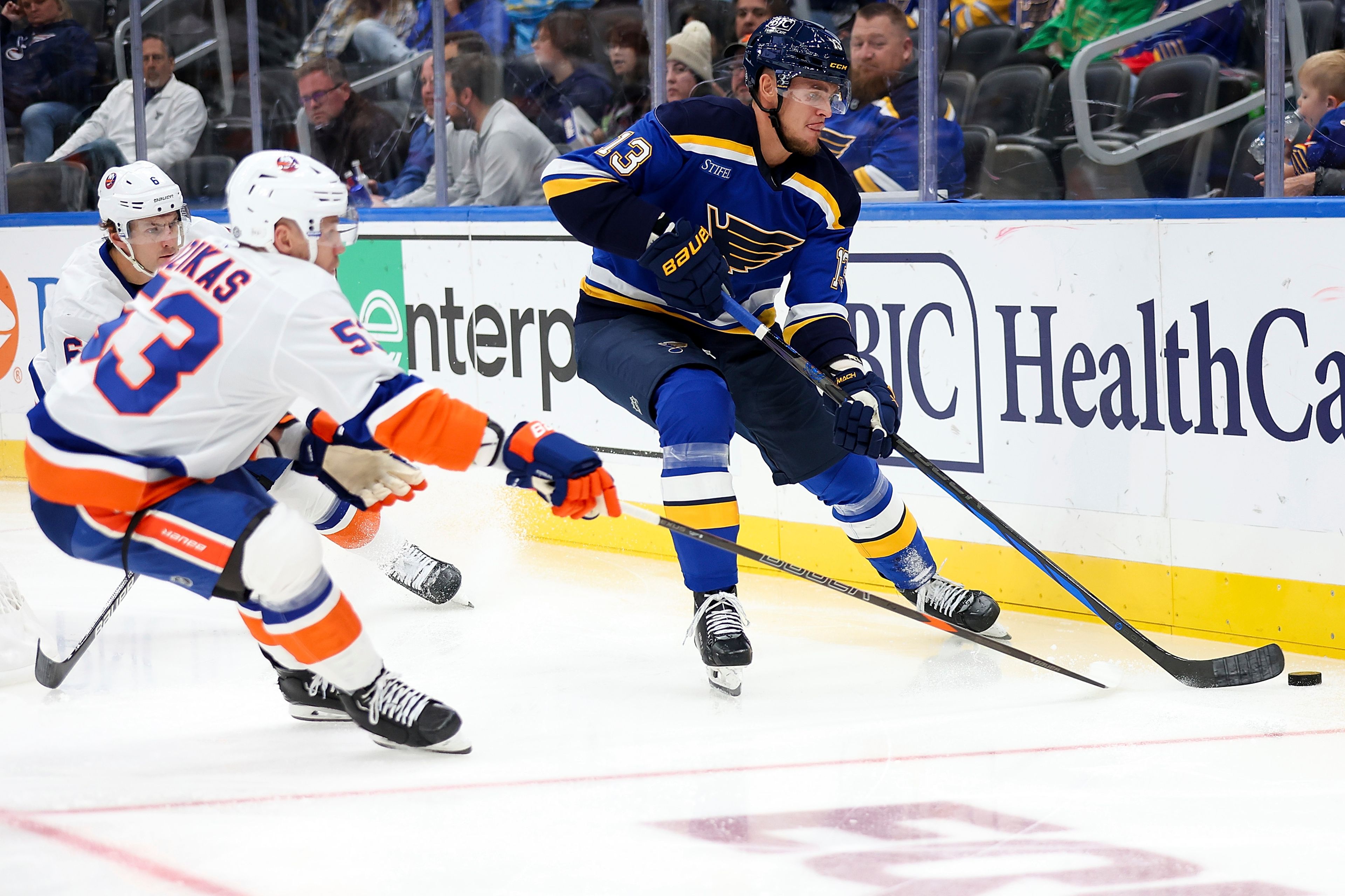 St. Louis Blues' Alexey Toropchenko (13) handles the puck while under pressure from New York Islanders' Casey Cizikas (53) during the second period of an NHL hockey game Thursday, Oct. 17, 2024, in St. Louis. (AP Photo/Scott Kane)