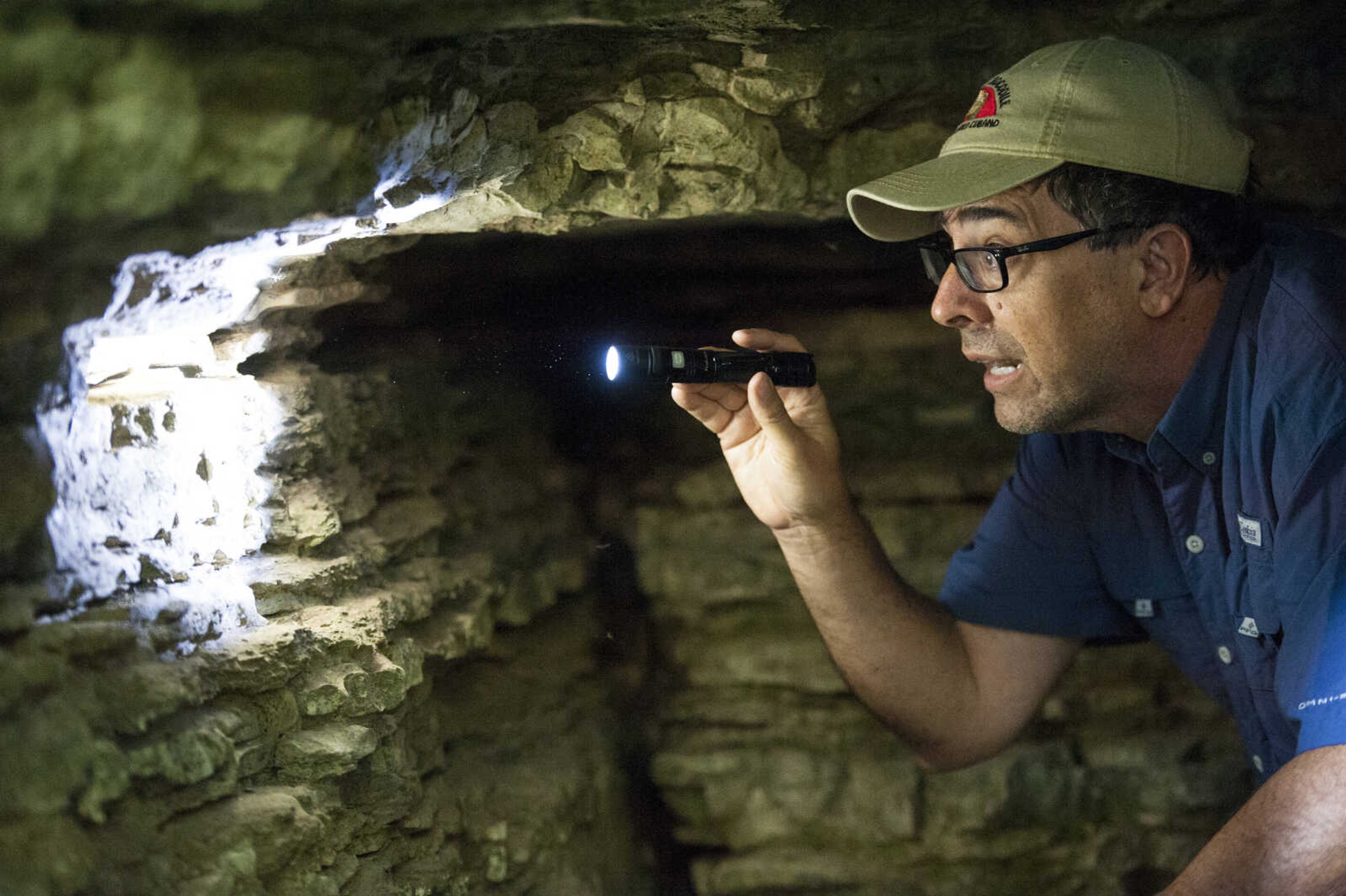 South Florida resident Dermot Bowden observes a pink salamander beneath a bluff Saturday, Oct. 5, 2019, near Snake Road in Wolf Lake, Illinois.