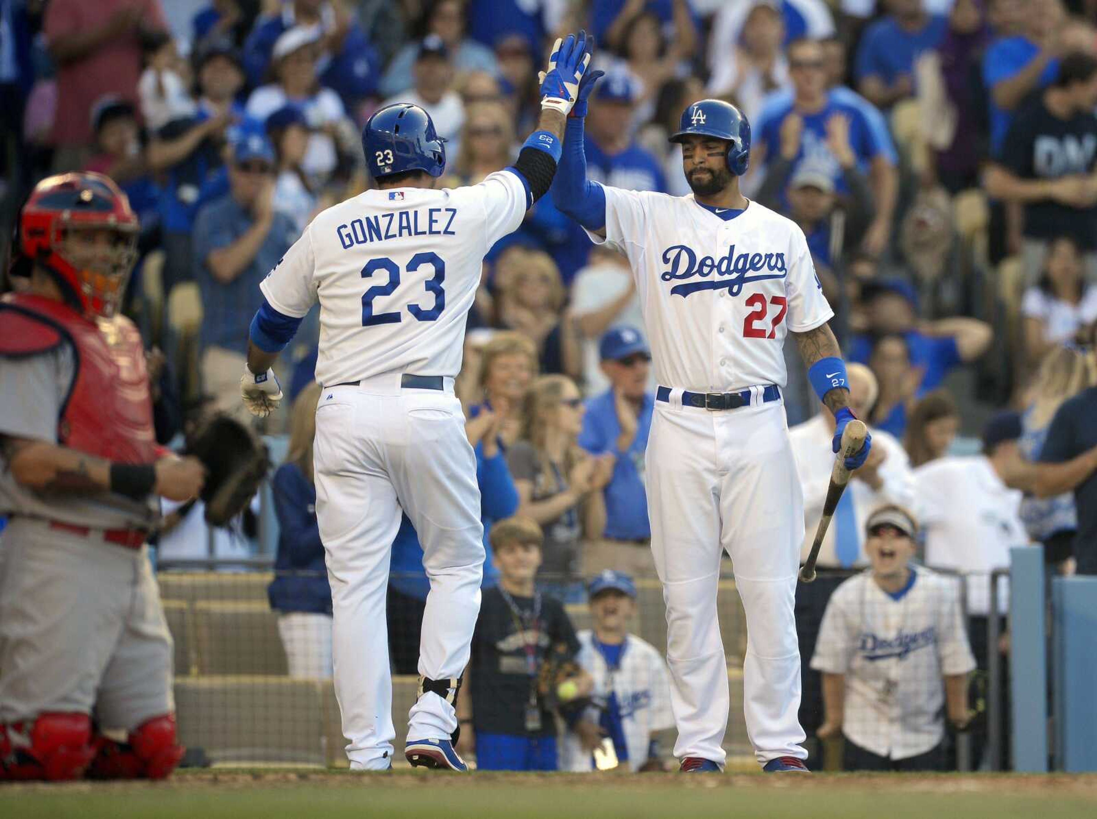 The Dodgers&#8217; Adrian Gonzalez (23) is congratulated by teammate Matt Kemp (27) as Cardinals catcher Yadier Molina looks on after Gonzalez hit a solo home run during the fifth inning Saturday in Los Angeles. (Mark J. Terrill ~ Associated Press)