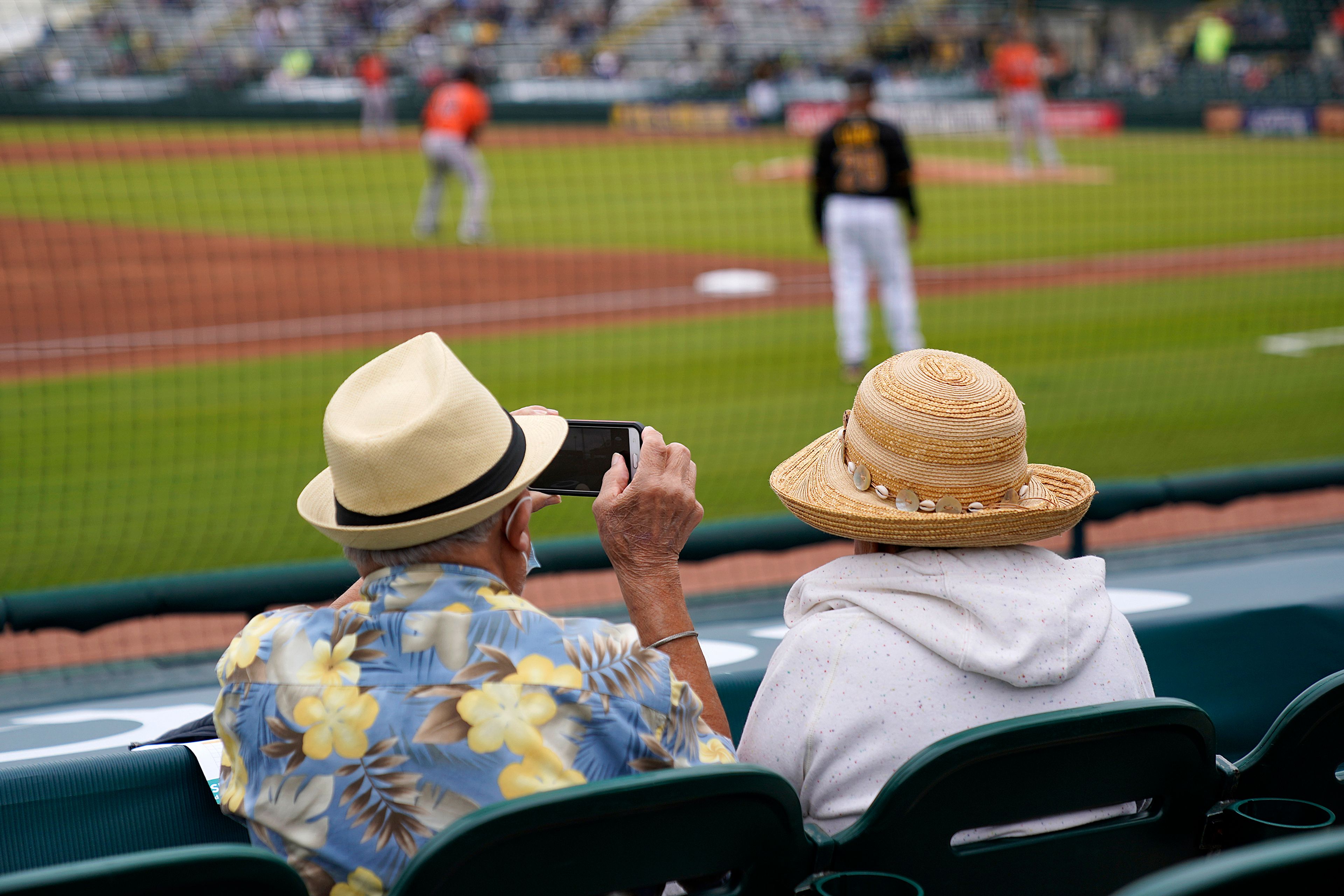 FILE - Baseball fans watch a spring training exhibition baseball game between the Pittsburgh Pirates and the Baltimore Orioles in Bradenton, Fla., March 22, 2021. (AP Photo/Gene J. Puskar, File)