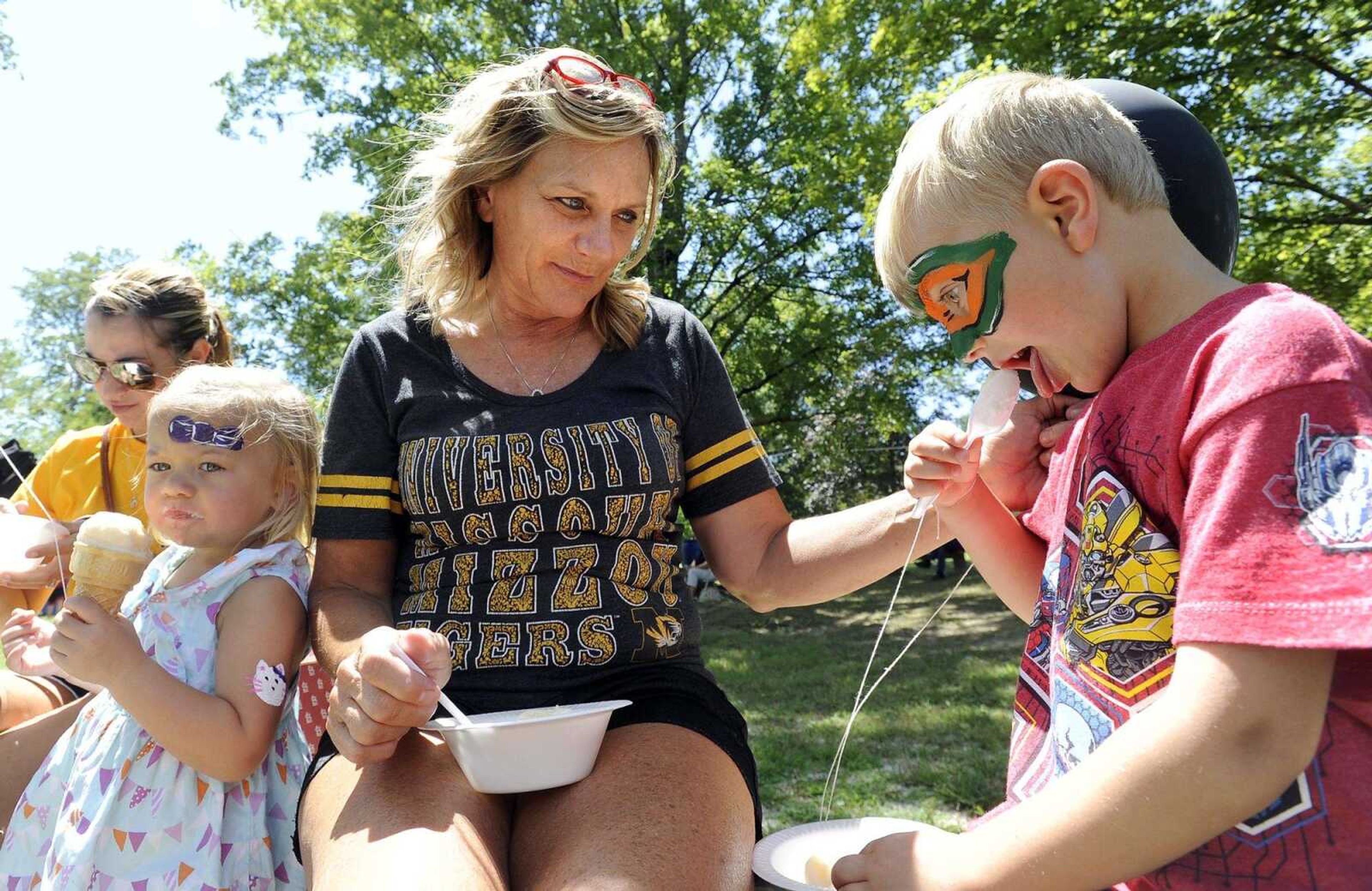 Paxton Essner, right, enjoys homemade ice cream with his grandmother, Tammy Van Gennip, his sister, Finley Essner, and his aunt, Maryssa Essner, on Saturday at the St. John's Church Picnic in Leopold, Missouri.