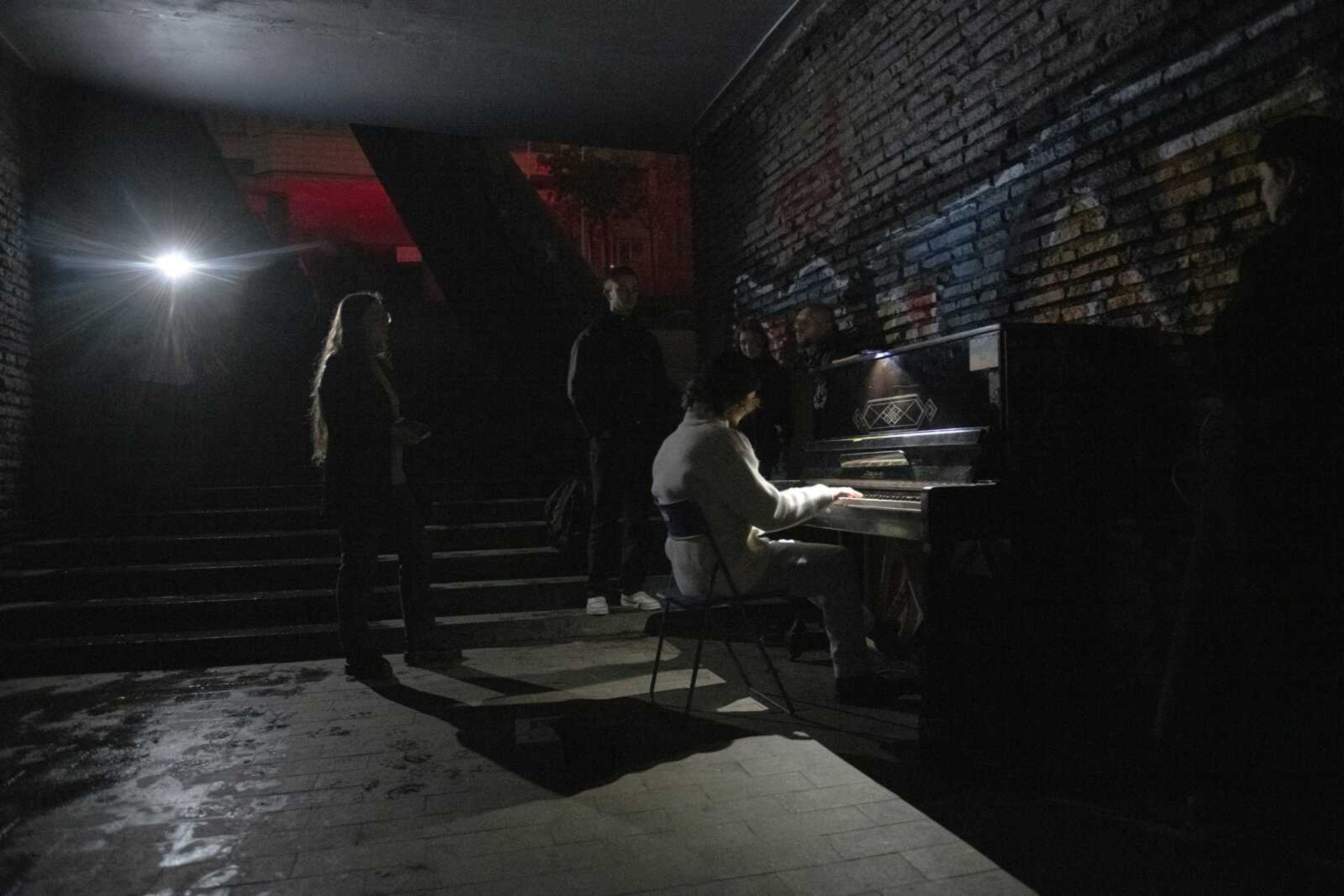 A person plays a piano in a street underpass during a blackout Nov. 6 in Kyiv, Ukraine. The hard realities of Ukraine's capital are that a once comfortably livable city of 3 million people is now becoming a tough place to live. But Kyiv has hope, resilience and defiance in abundance. And perhaps more so now than at any time since Russia invaded Ukraine nine months ago.