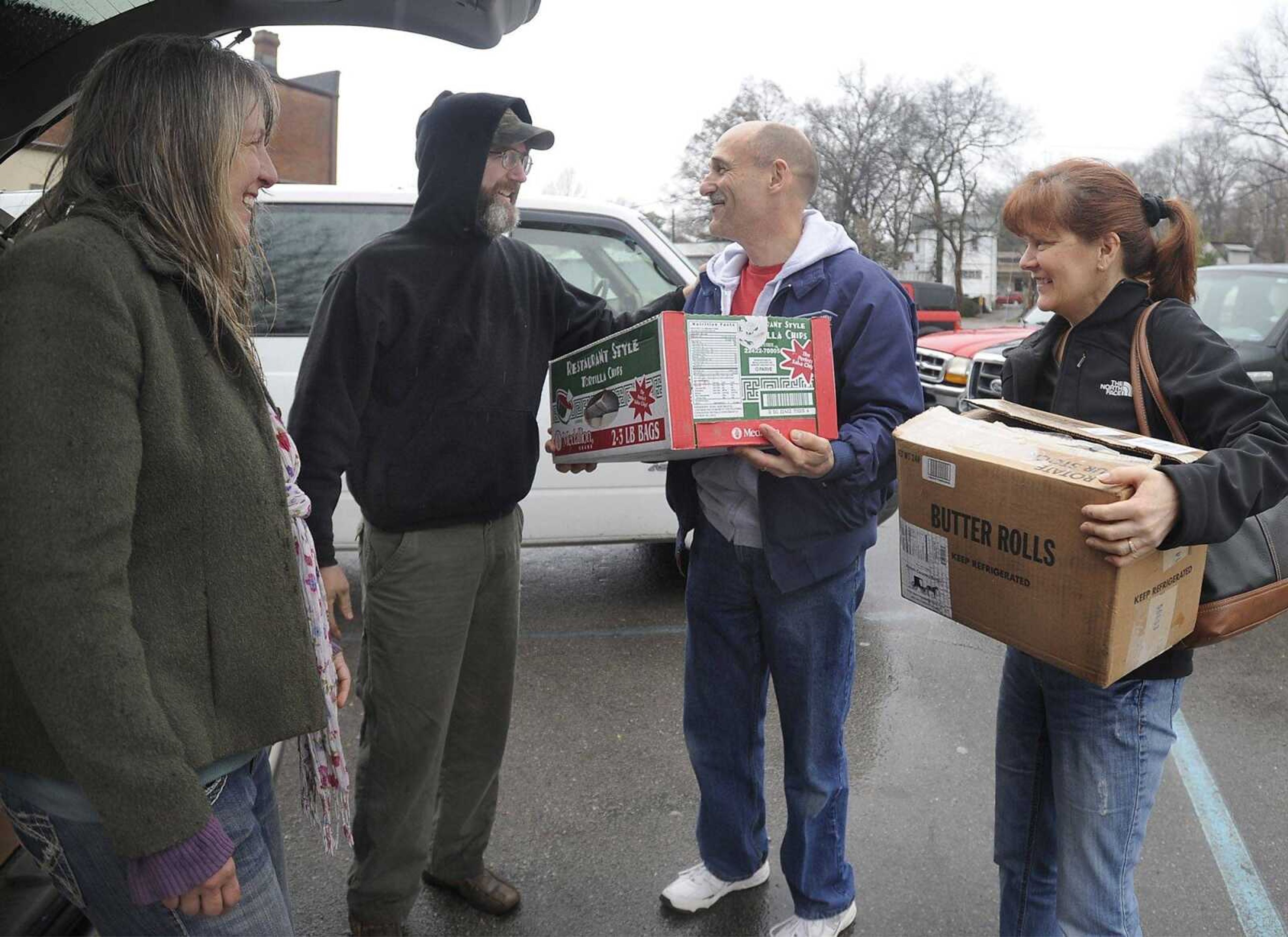 Sharla and Lance Green, left, deliver locally grown foods to Ed and Barbara Smith of Jackson at a downtown parking lot Saturday in Cape Girardeau. The Smiths ordered eggs, bread, lamb and ice cream online from Cape Locally Grown. (Fred Lynch)