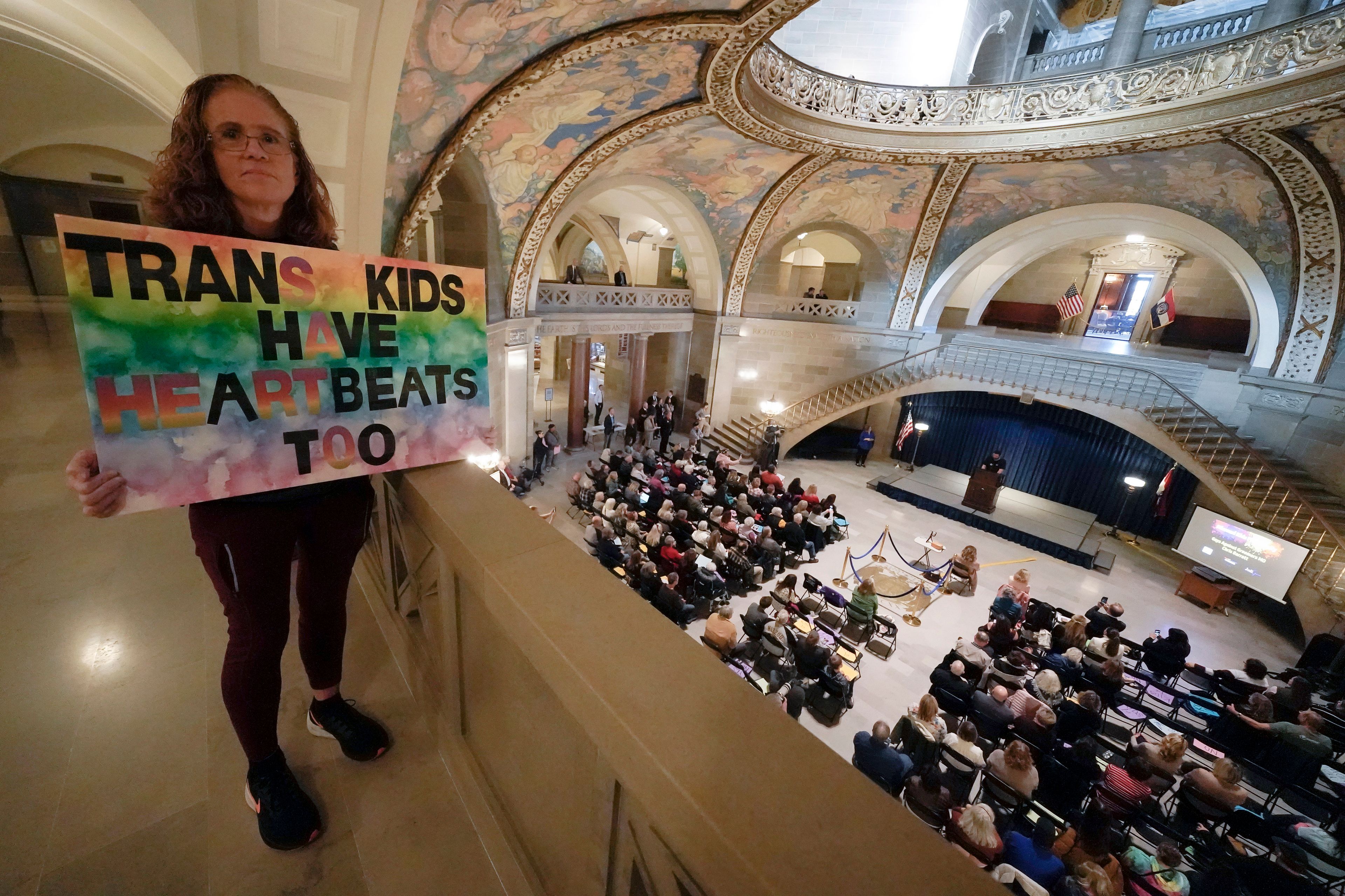 FILE - Julia Williams holds a sign in counterprotest during a rally in favor of a ban on gender-affirming health care legislation, Monday, March 20, 2023, at the Missouri Statehouse in Jefferson City, Mo. (AP Photo/Charlie Riedel, File)