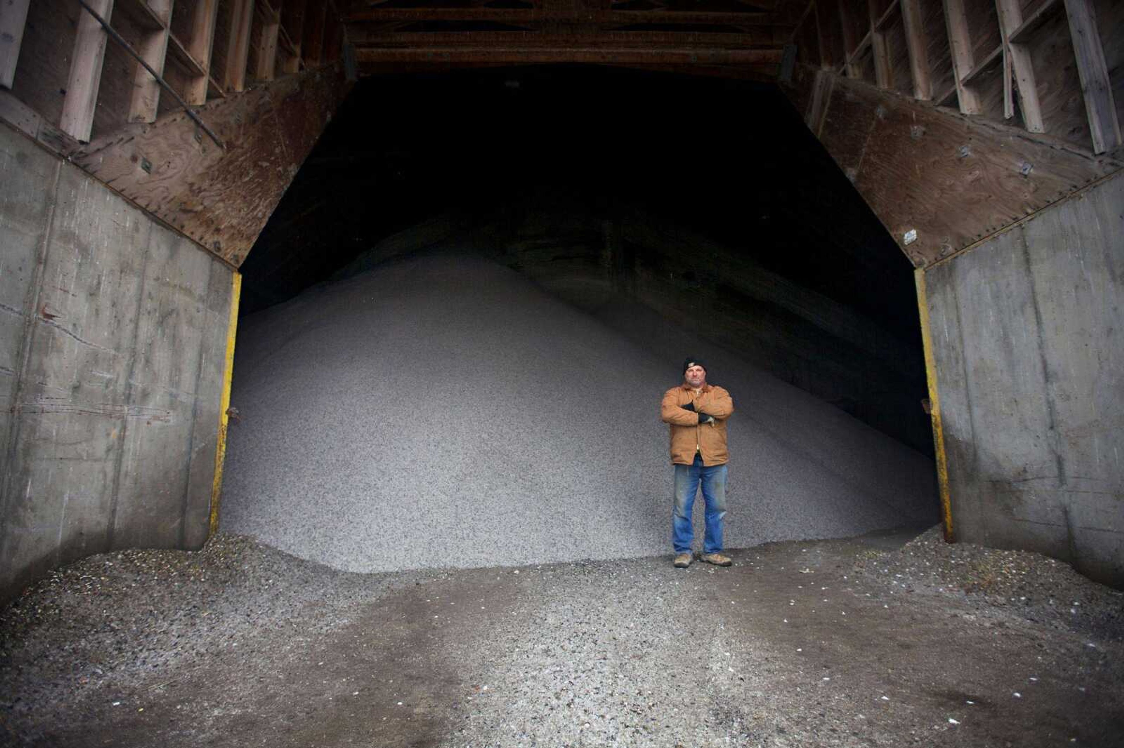 Jeff Gould, lead equipment operator for the Department of Public Works in Sioux Falls, S.D., stands in front of a giant salt dome filled with rock salt Wednesday. Gould says the pile would be half this size by this time during a normal winter. (Amber Hunt ~ Associated Press)