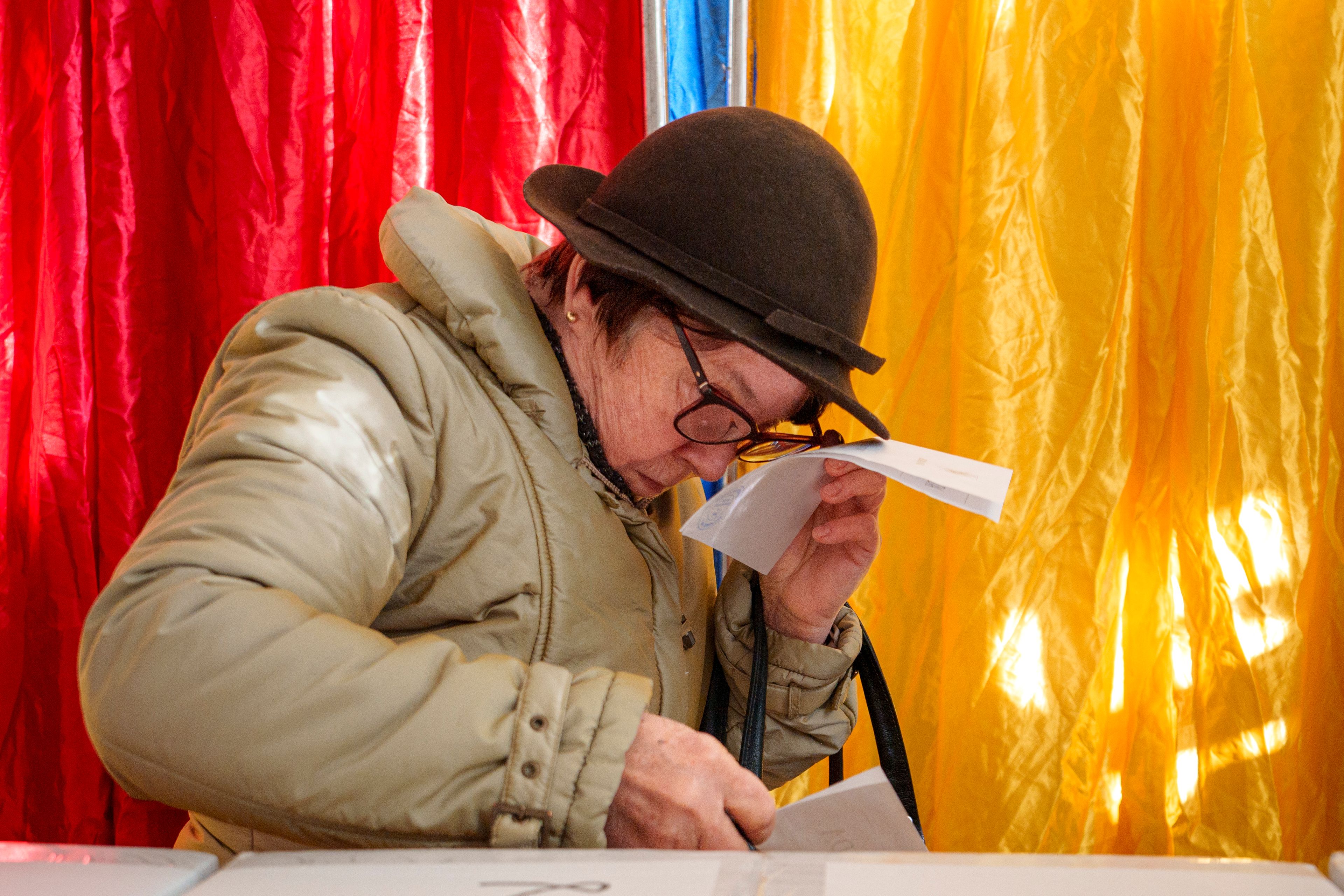 A woman adjusts her glasses before casting her vote in the country's presidential elections, in Bucharest, Romania, Sunday, Nov. 24, 2024. (AP Photo/Andreea Alexandru)