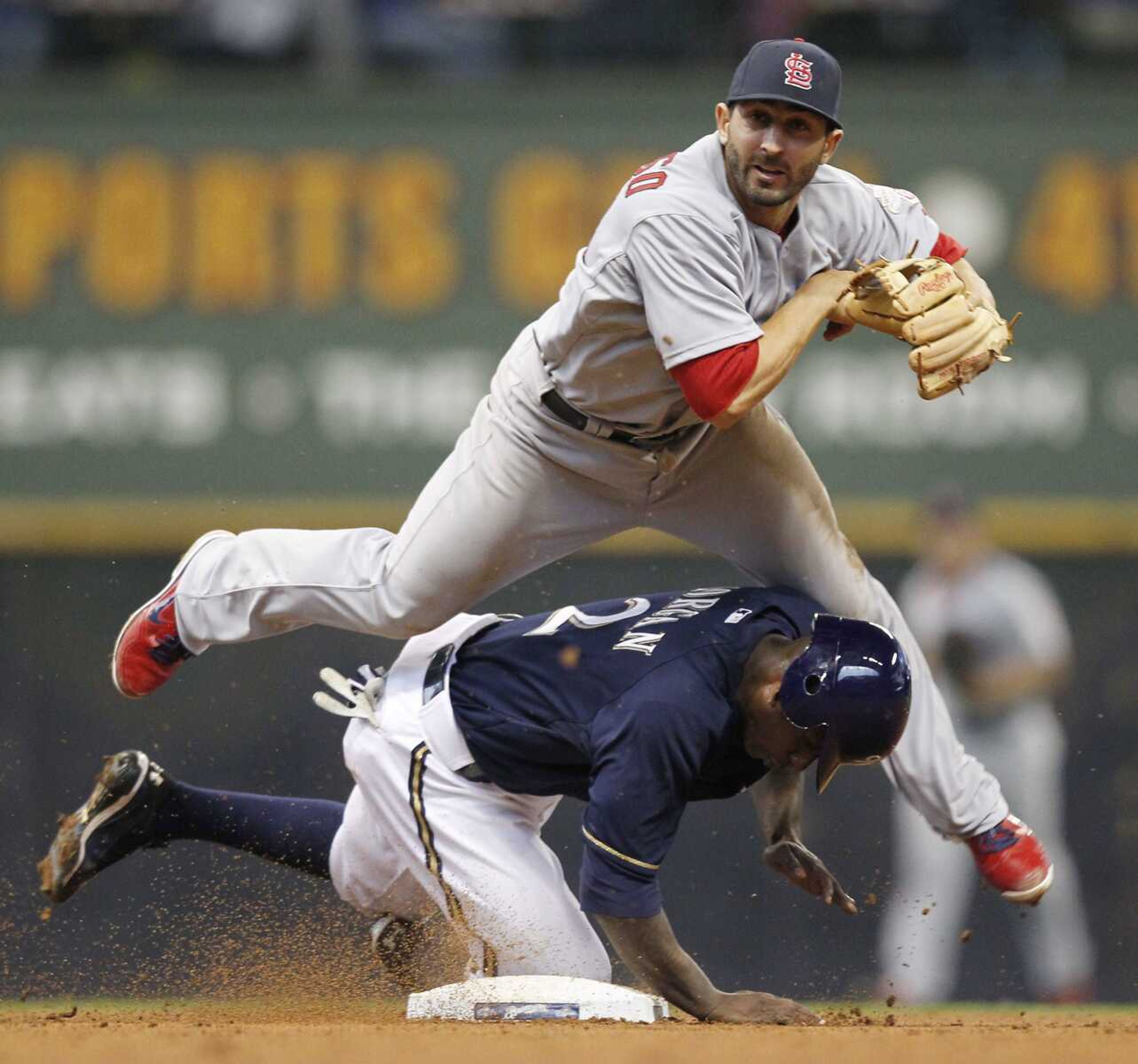 Cardinals second baseman Daniel Descalso forces out Brewers baserunner Nyjer Morgan and throws to first base during the sixth inning Saturday in Milwaukee. (JEFFREY PHELPS ~ Associated Press)