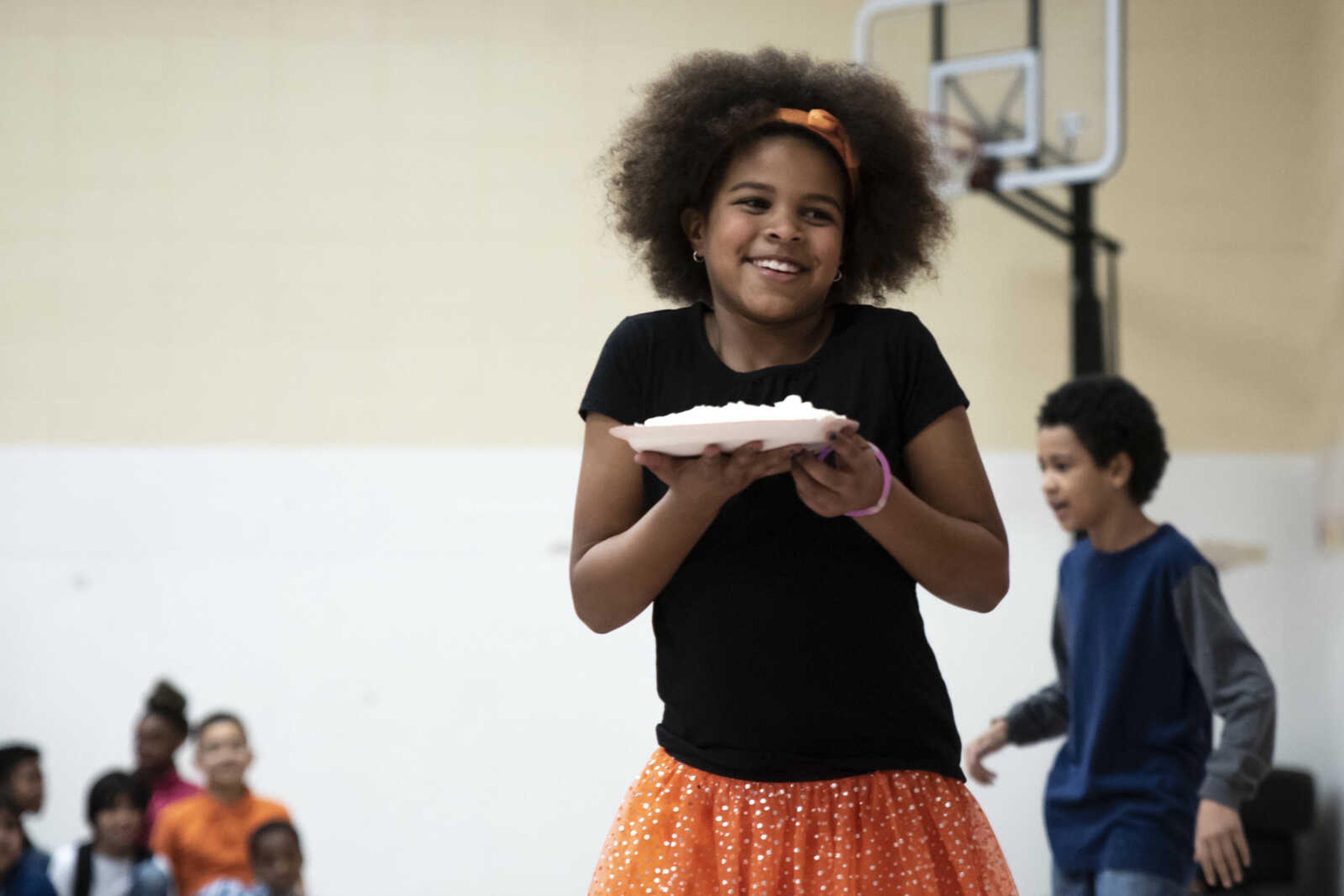 Second grader Kayden Kirn smiles as she prepares to pie Charity Owens (not pictured) in the face at Clippard Elementary School Friday, April 5, 2019, in Cape Girardeau. Students earned votes for which teacher(s) would get pied in the face when they brought in donations to raise money for their end-of-the-year play day that is free to students. Through students and other donations, the school raised $550 towards their play day activities.