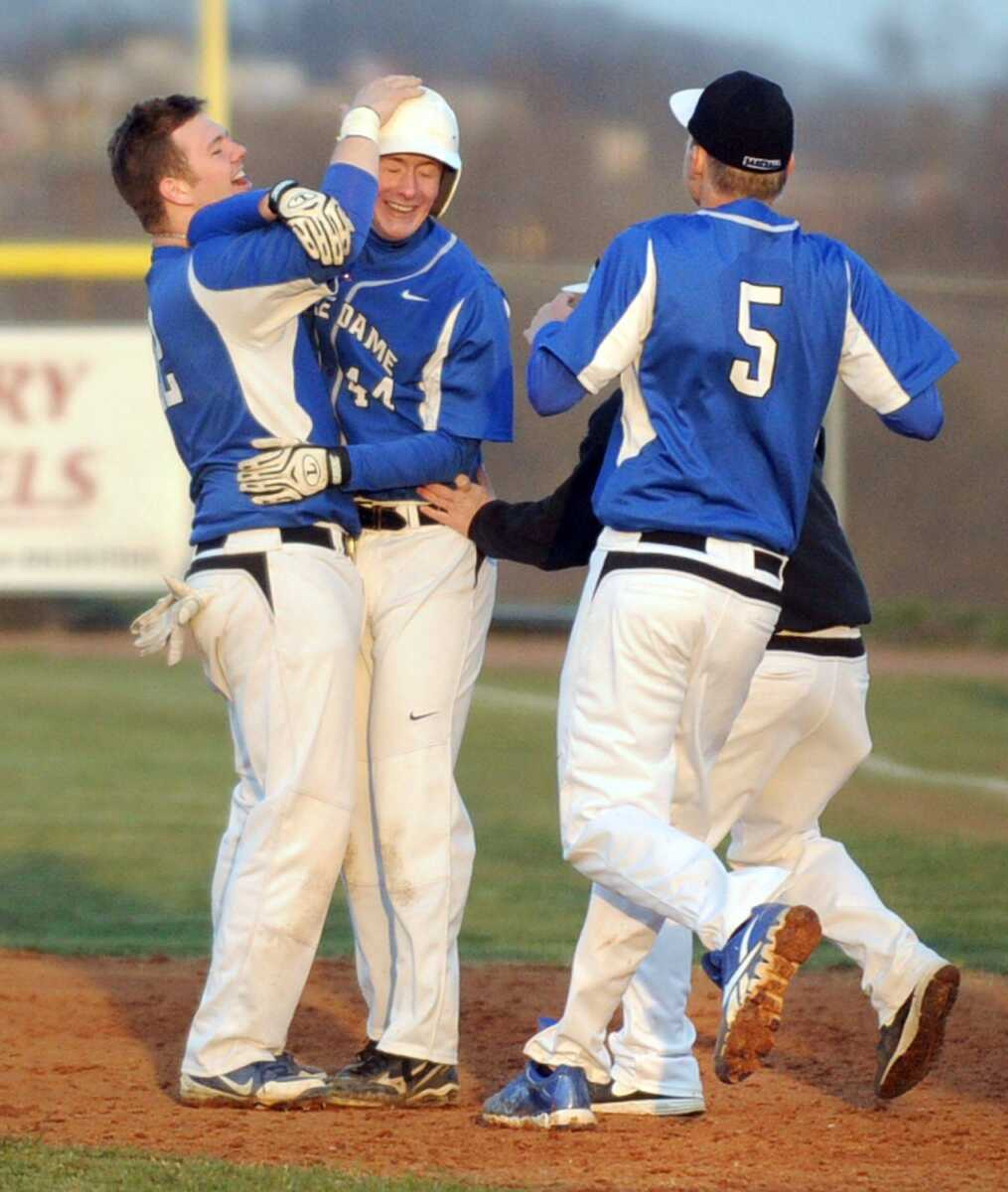 Notre Dame players surround teammate Matt Westrich to celebrate his game winning RBI in the tenth inning of the Bulldogs' 3-2 win over Cape Central in the 10th inning Monday, April 1, 2013 at Notre Dame. (Laura Simon)