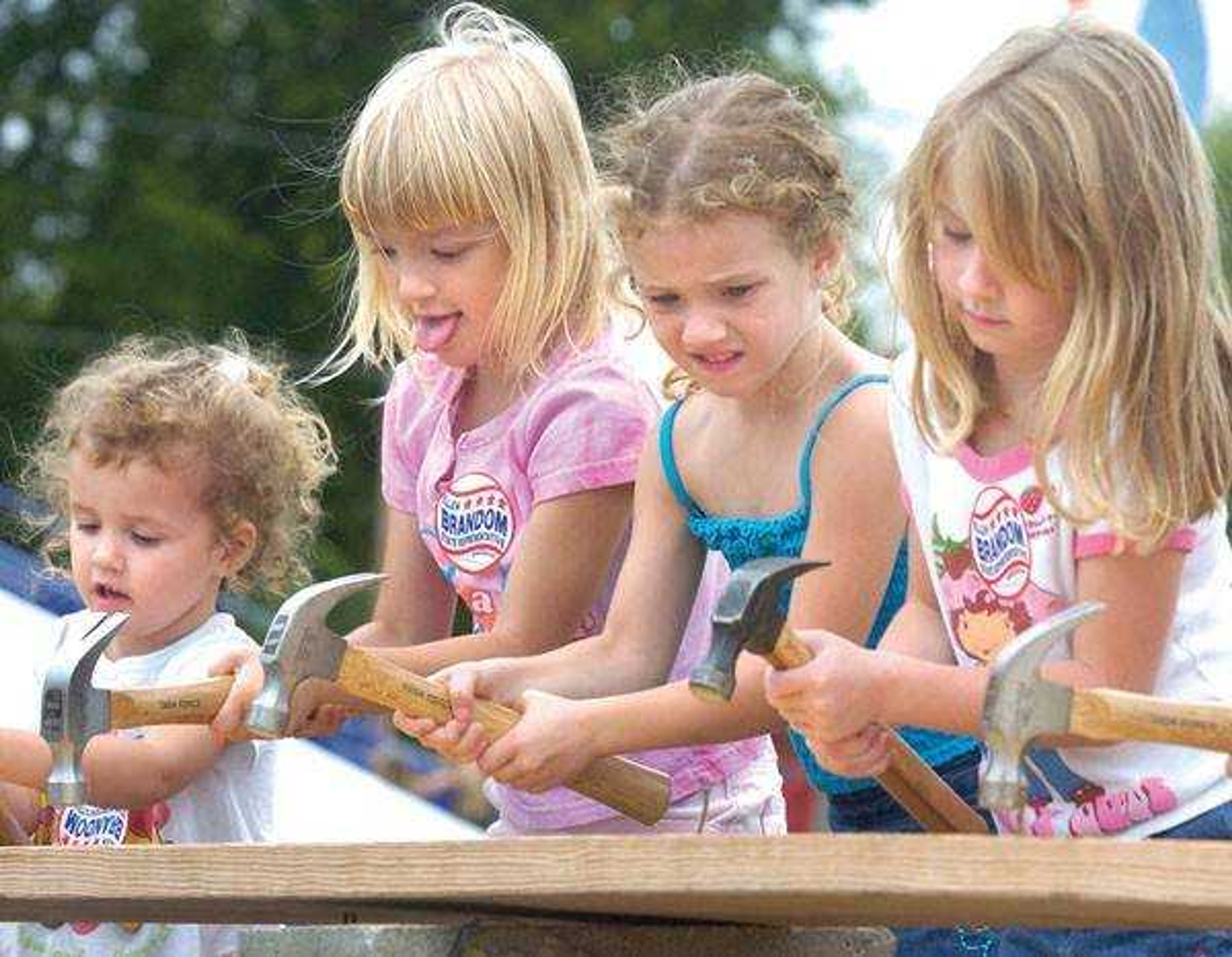 Nail driving is one of the old-fashioned contests in which these girls competed at Benton Neighbor Days. (Fred Lynch)