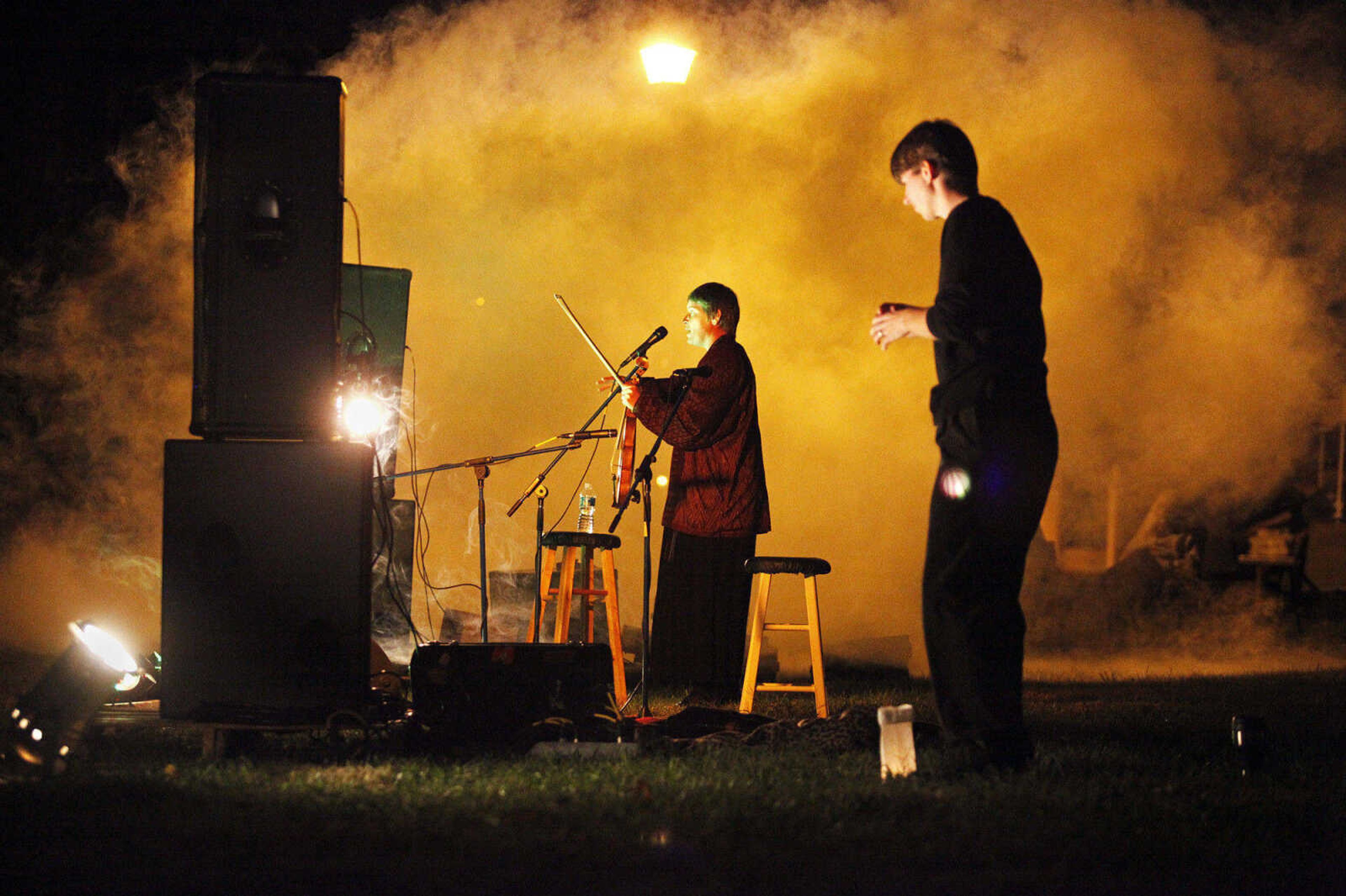 CHRIS MACKLER ~ photos@semissourian.com

Storyteller Jennifer Armstrong, left, plays her fiddle while sign language interpreter Jessica Lagona, right, signs during the Ghost Storytelling Festival held near the Old Beech Tree on the east lawn of Southeast Missouri State University's River Campus in Cape Girardeau on Friday, Oct. 15, 2010. According to Chuck Martin, Executive Director of the Cape Girardeau Convention and Visitors Bureau, around 650 people attended the event.